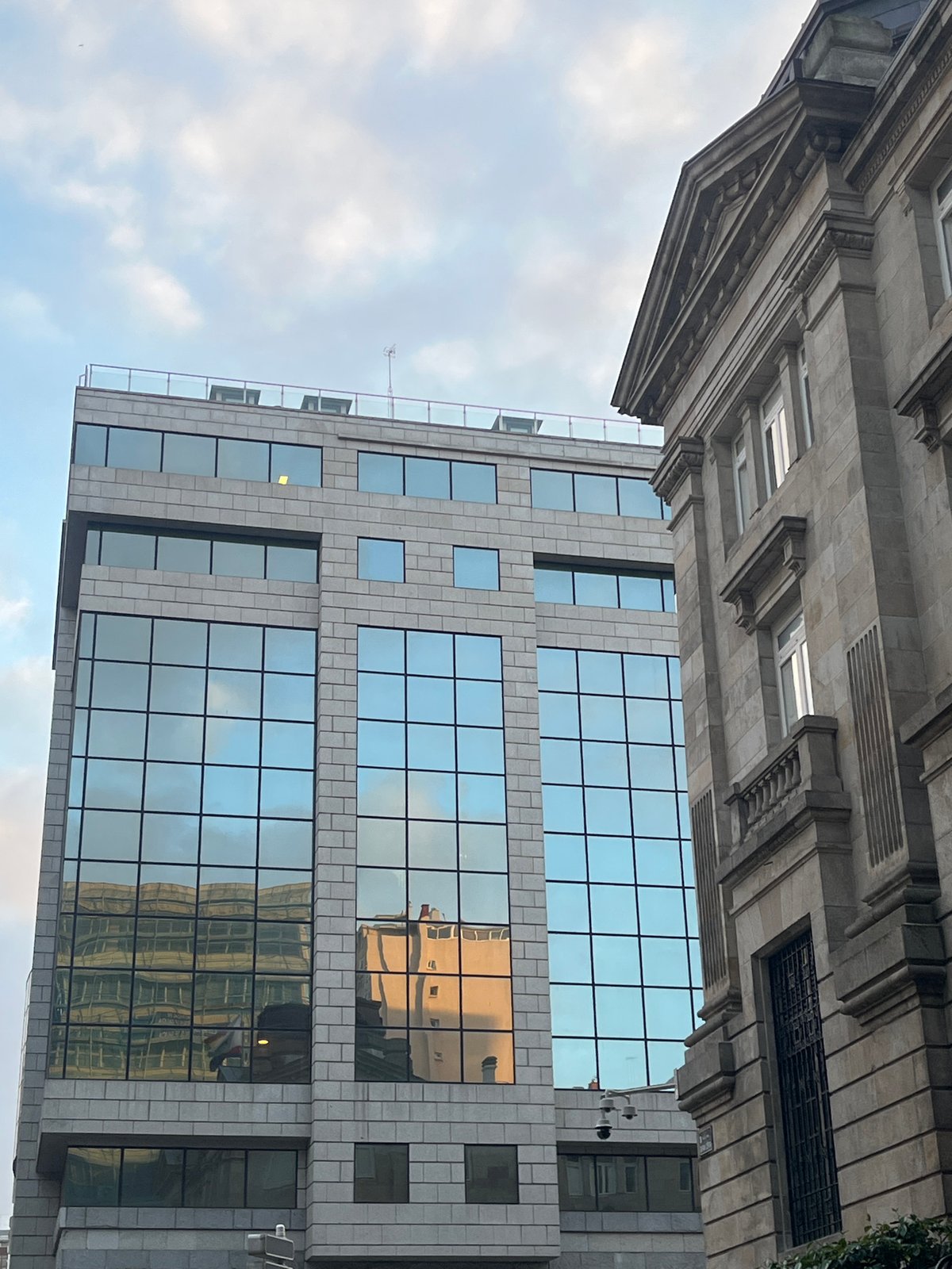Architectural contrast documented in A Coruña under cloudy evening sky