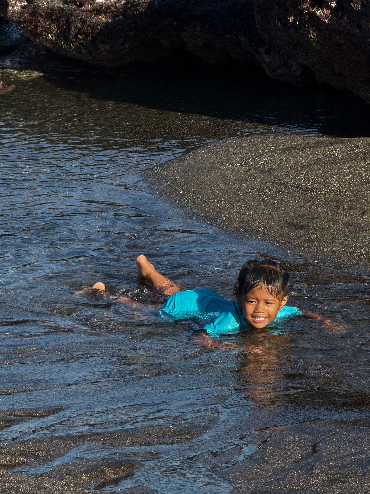 Morning beach activities on Mengwi's black sand shores