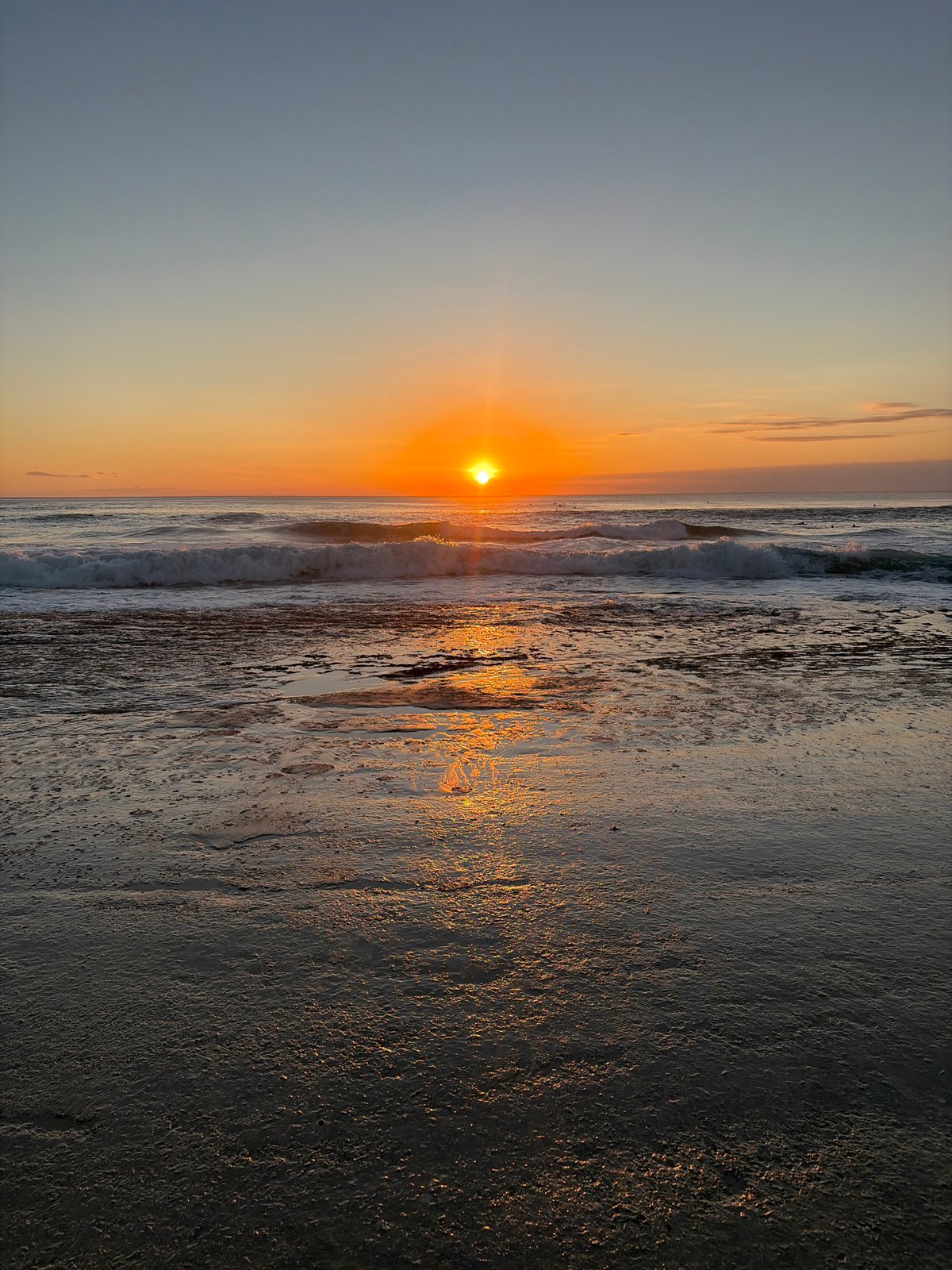 Golden sunset over the beach, sand, and breaking waves