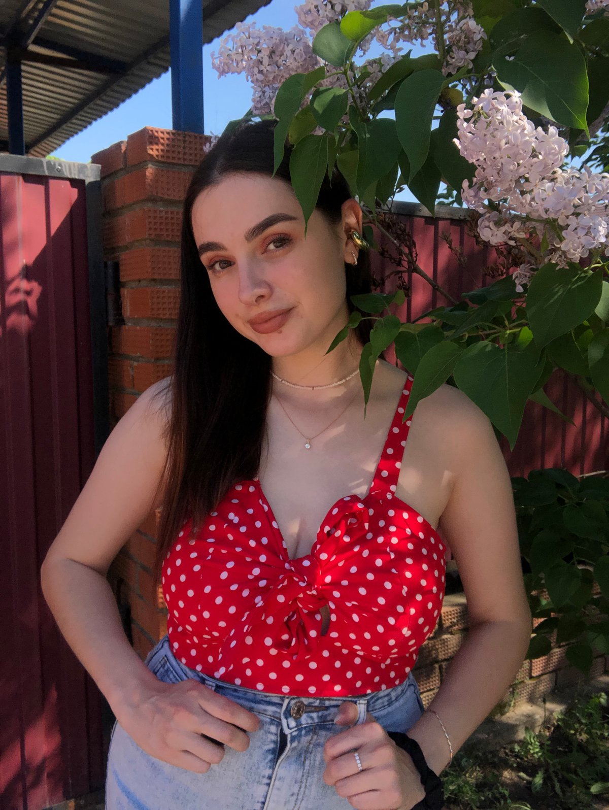 Woman poses with blooming lilacs during photo session in Noviy