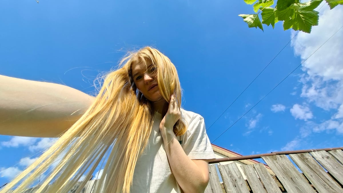 Woman takes garden selfies with pink peonies in Russian village