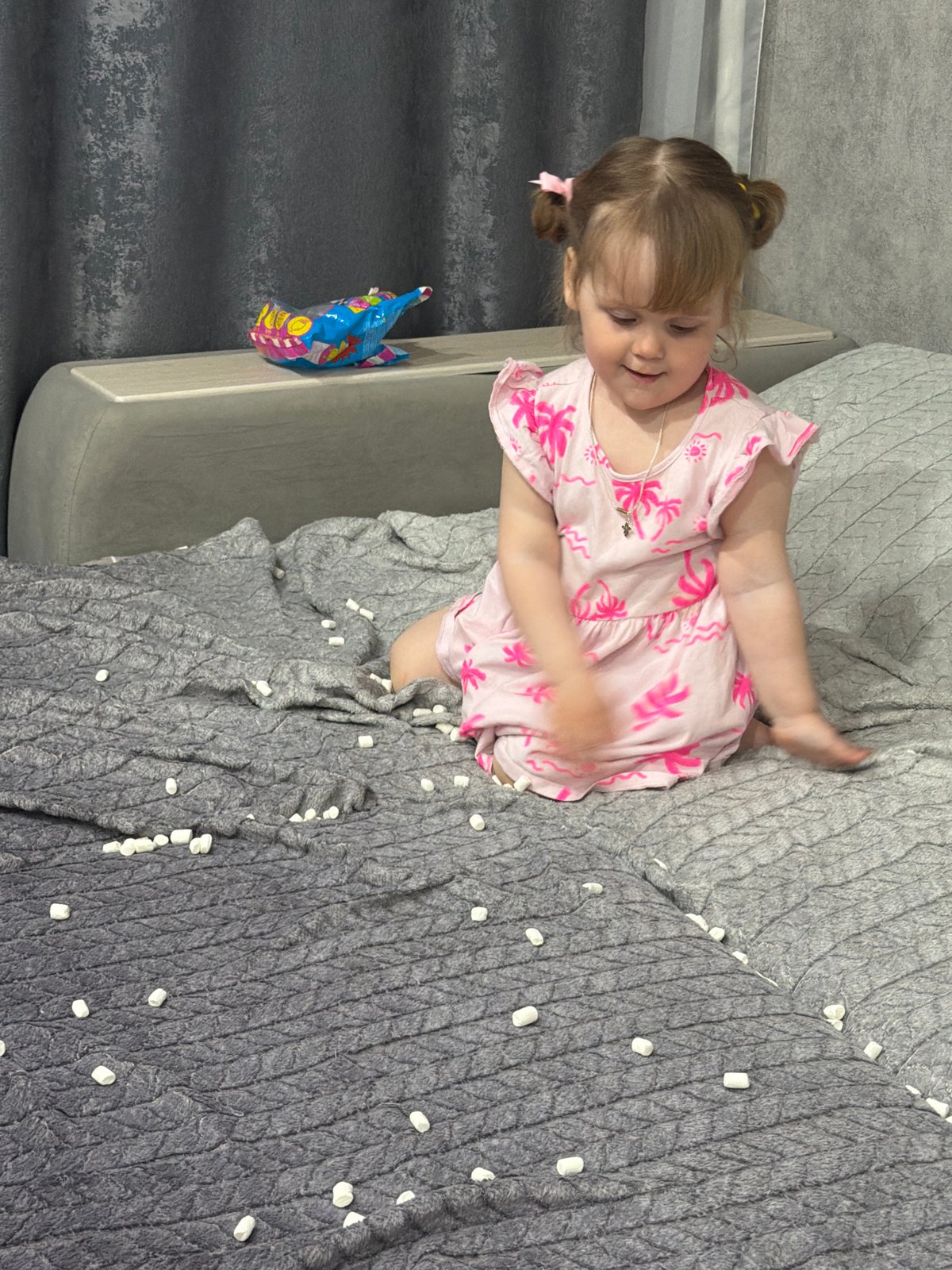 Toddler in pink dress plays indoors in Chaikovsky