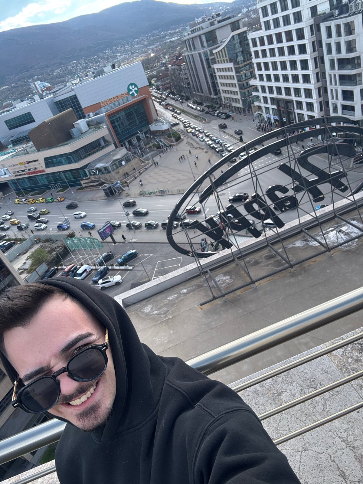 Man takes rooftop selfies overlooking Sofia cityscape and Vitosha Mountain