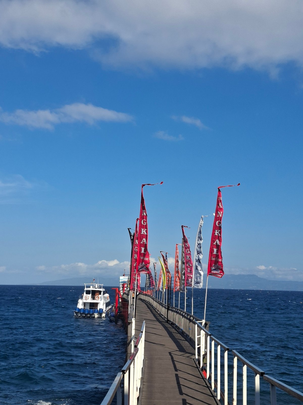 Flagged pier and boats on the Bali coast at Dawan