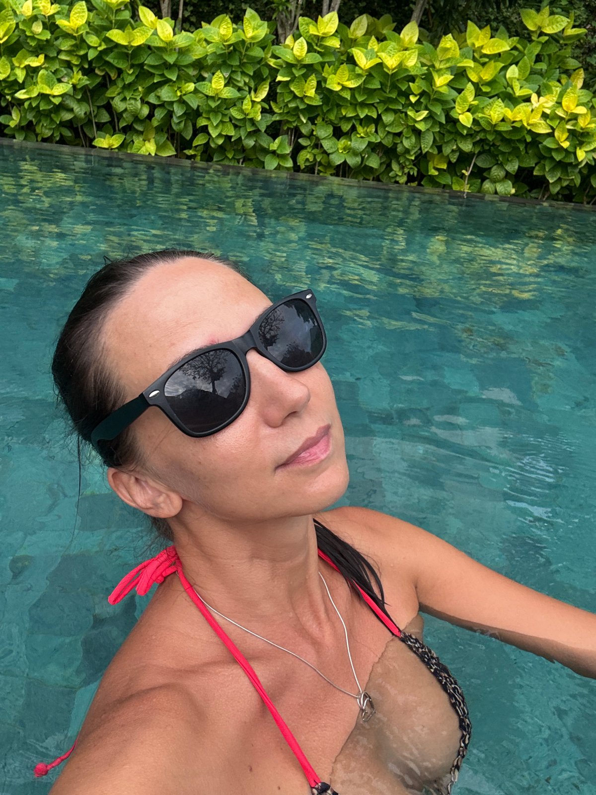 Woman enjoys morning pool time in Kuta Selatan resort