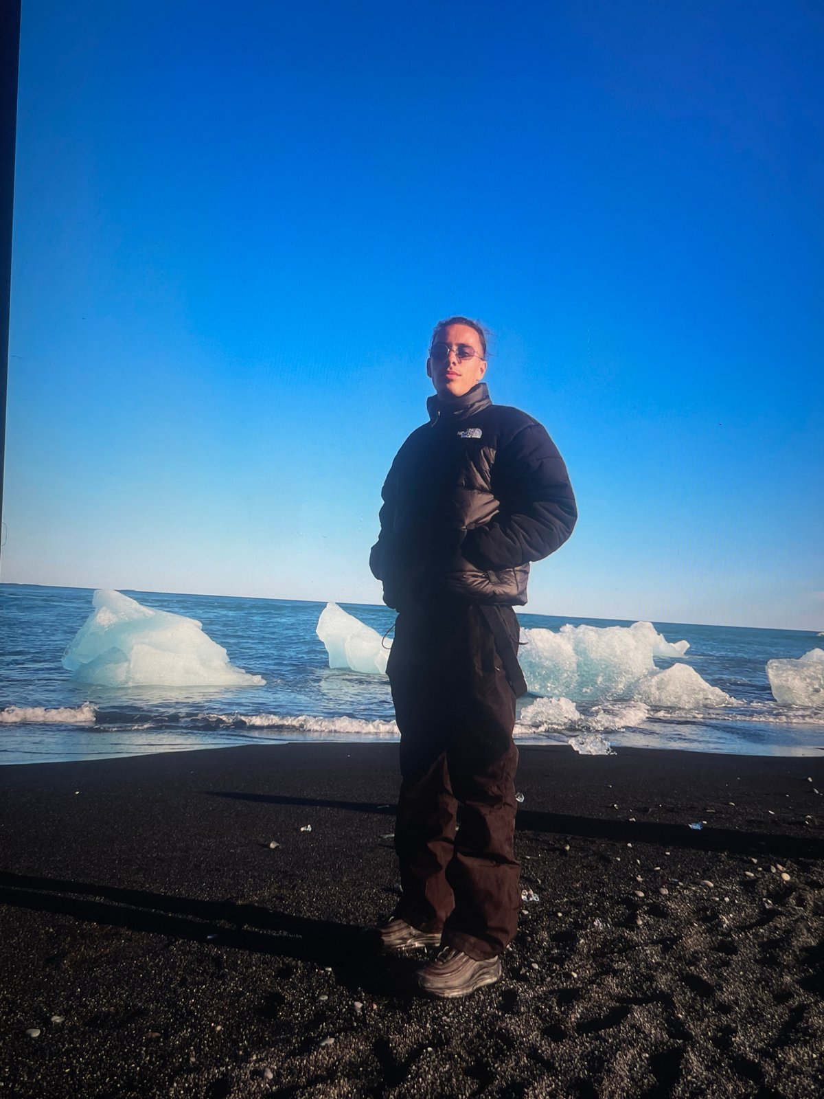 Tourists gather on Iceland's black sand beach amid icebergs