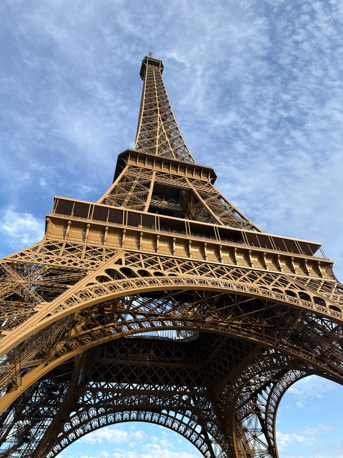 Eiffel Tower iron lattice reaching into a clear Paris sky