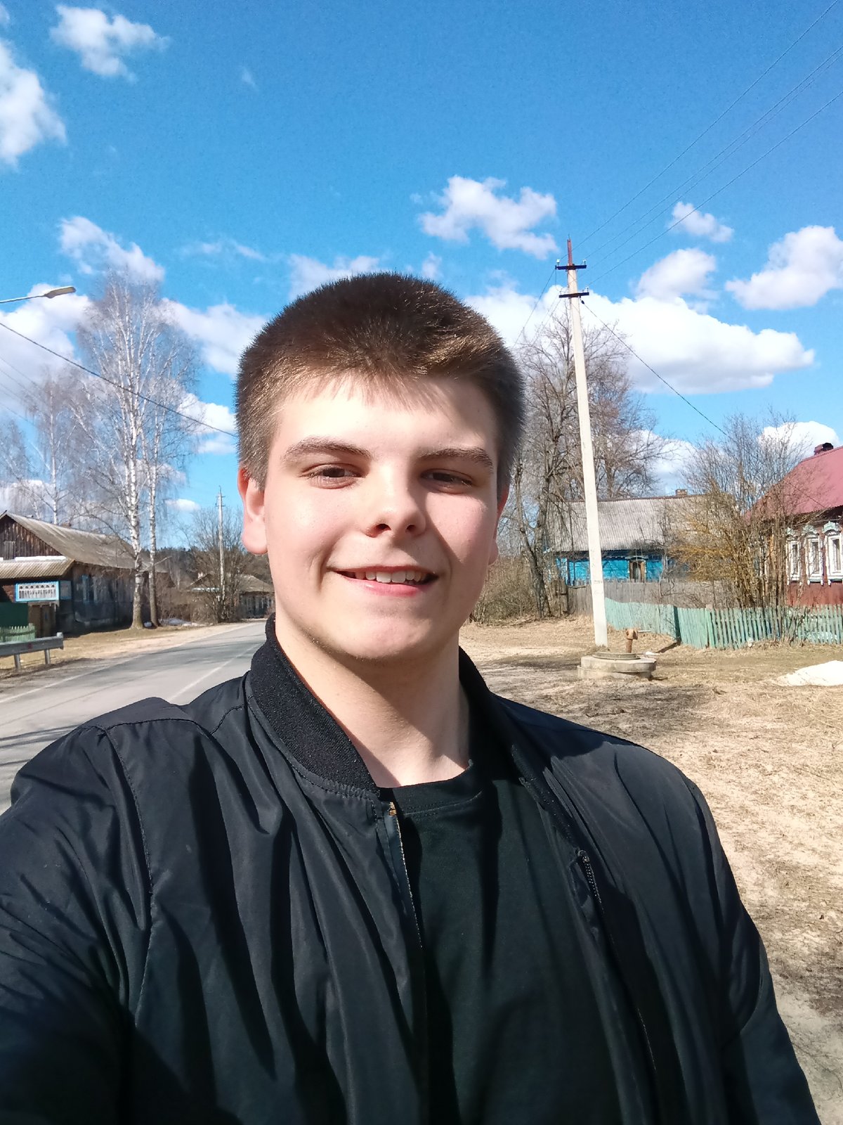 Young man poses for selfies on rural Russian road