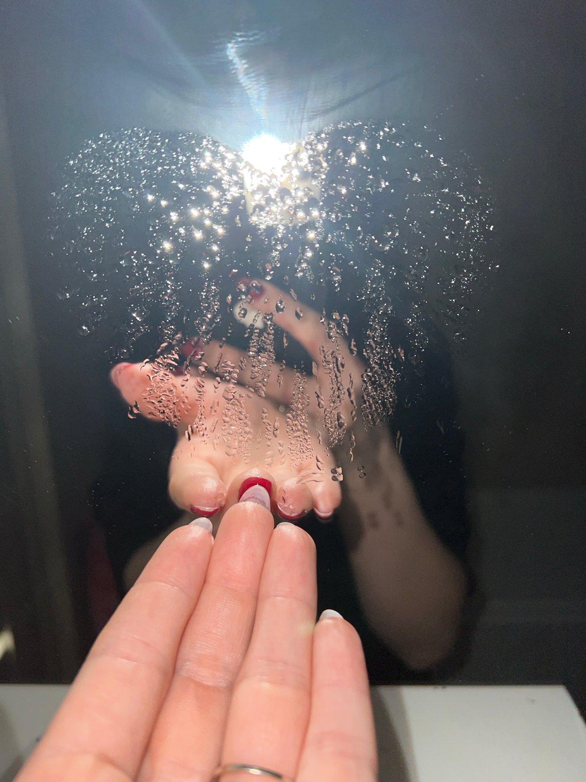 Hand touches wet reflective surface in Saint Petersburg