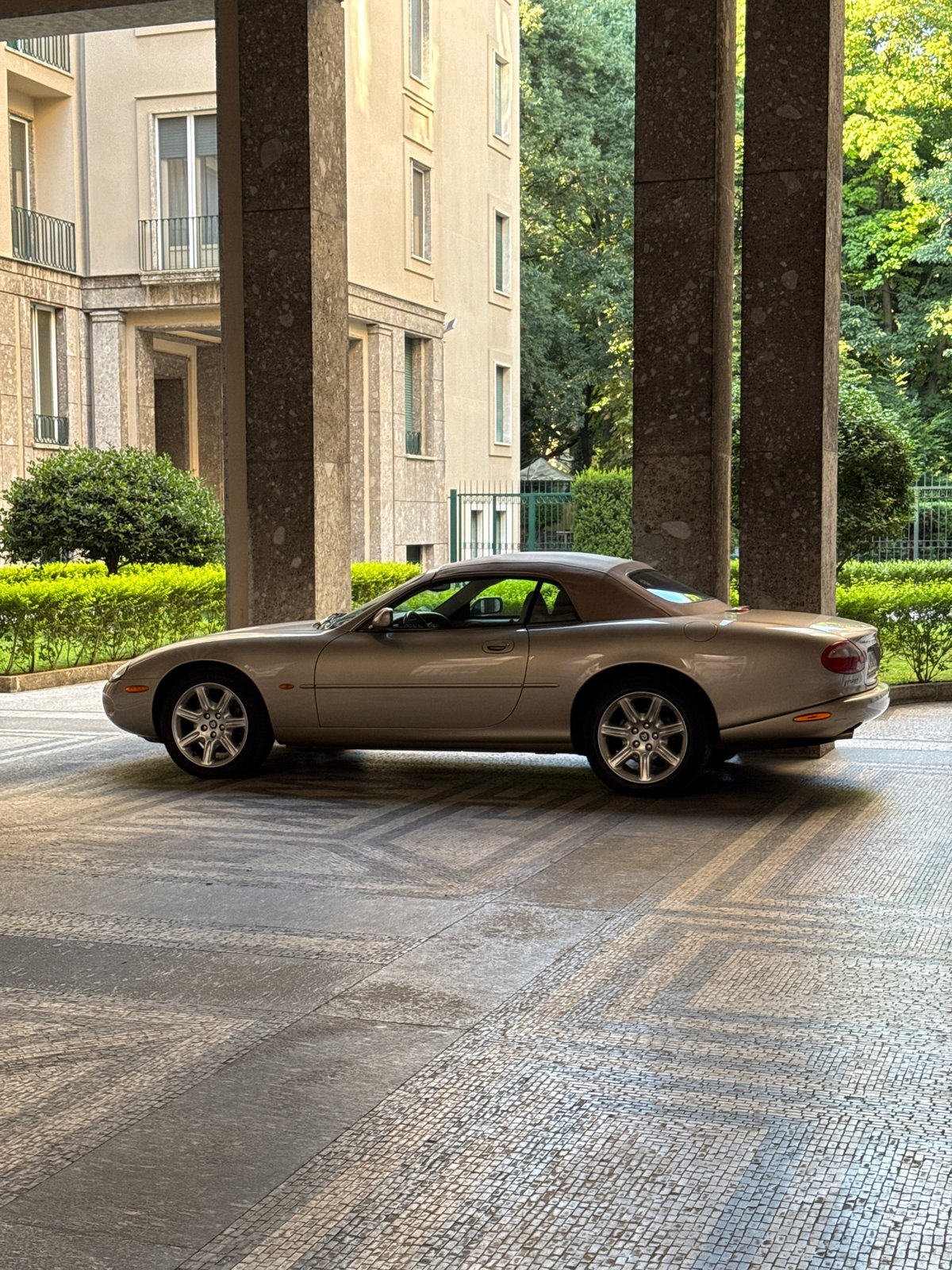 Silver Jaguar XK8 parked under Milan portico