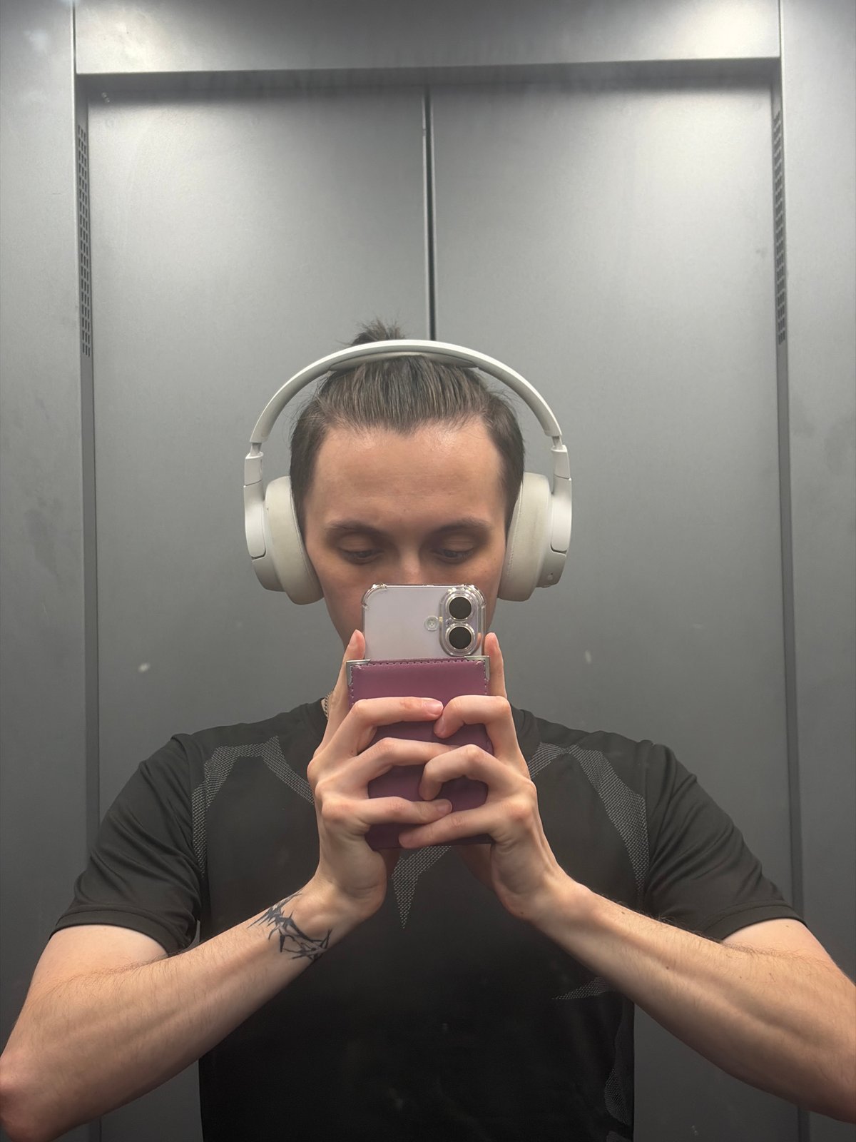 Elevator mirror selfie with headphones and geometric tee