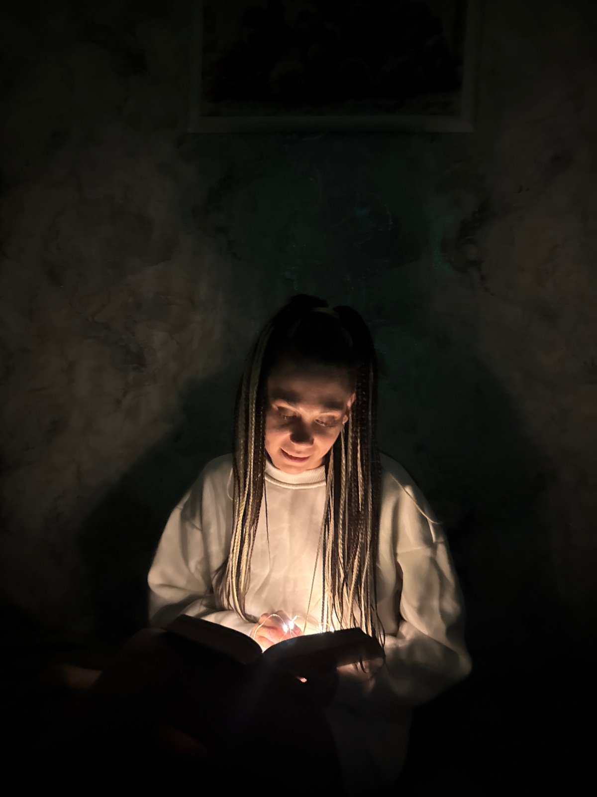 Woman with braided hair observed in dimly lit indoor space