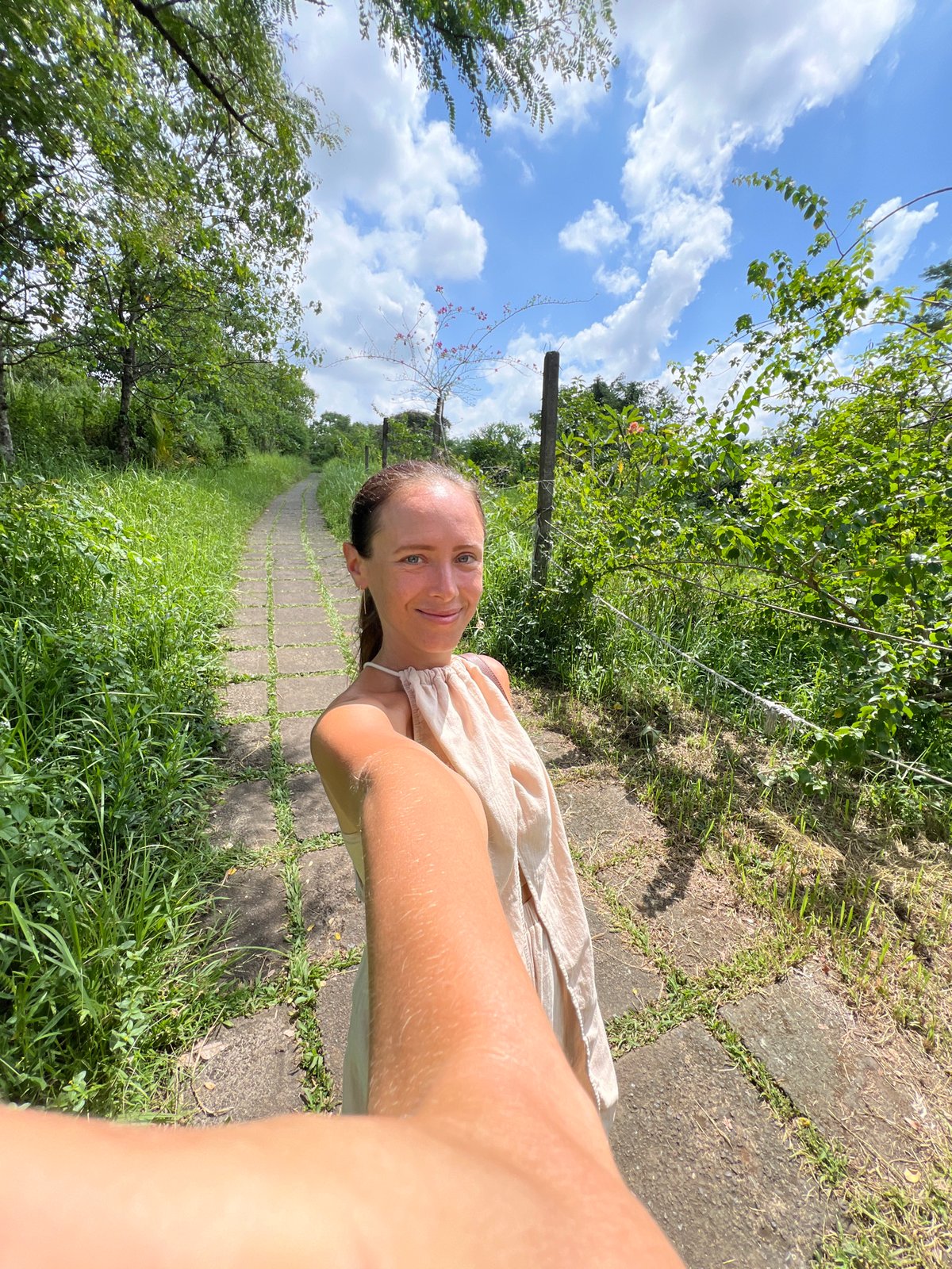 Woman takes selfie on stone pathway in Ubud