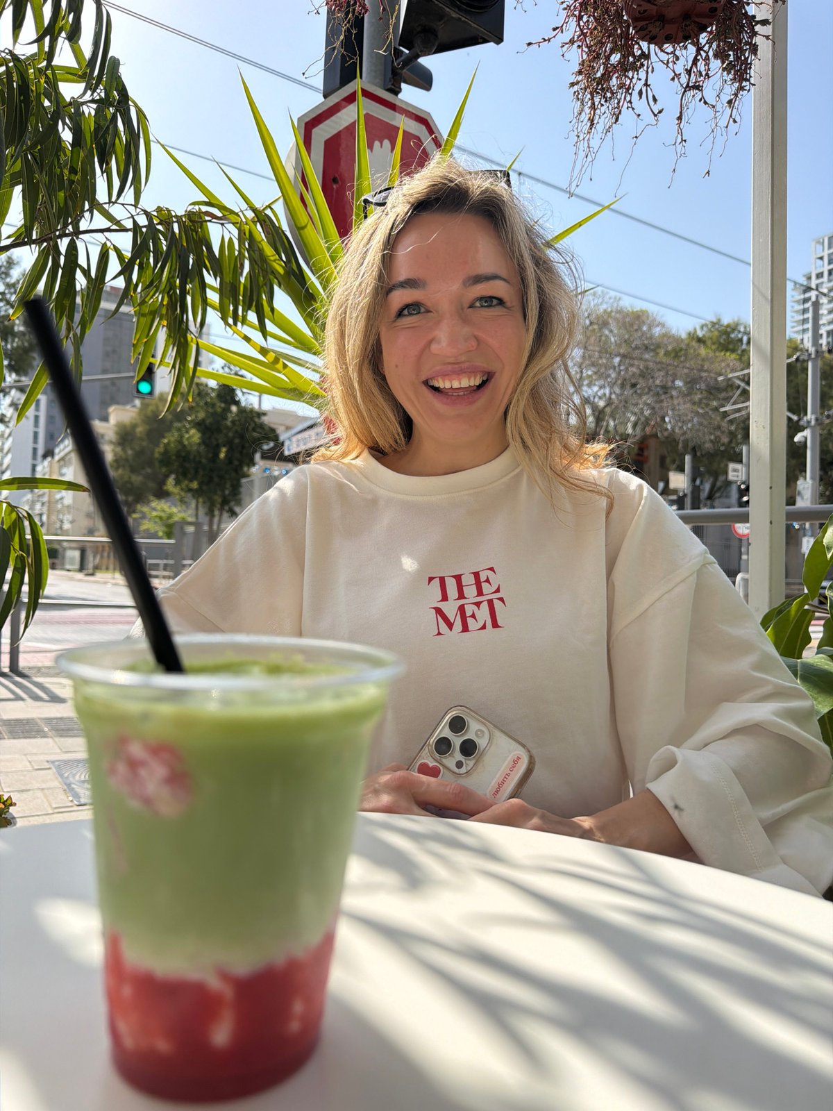 Woman photographed smiling at outdoor cafe in Bat Yam
