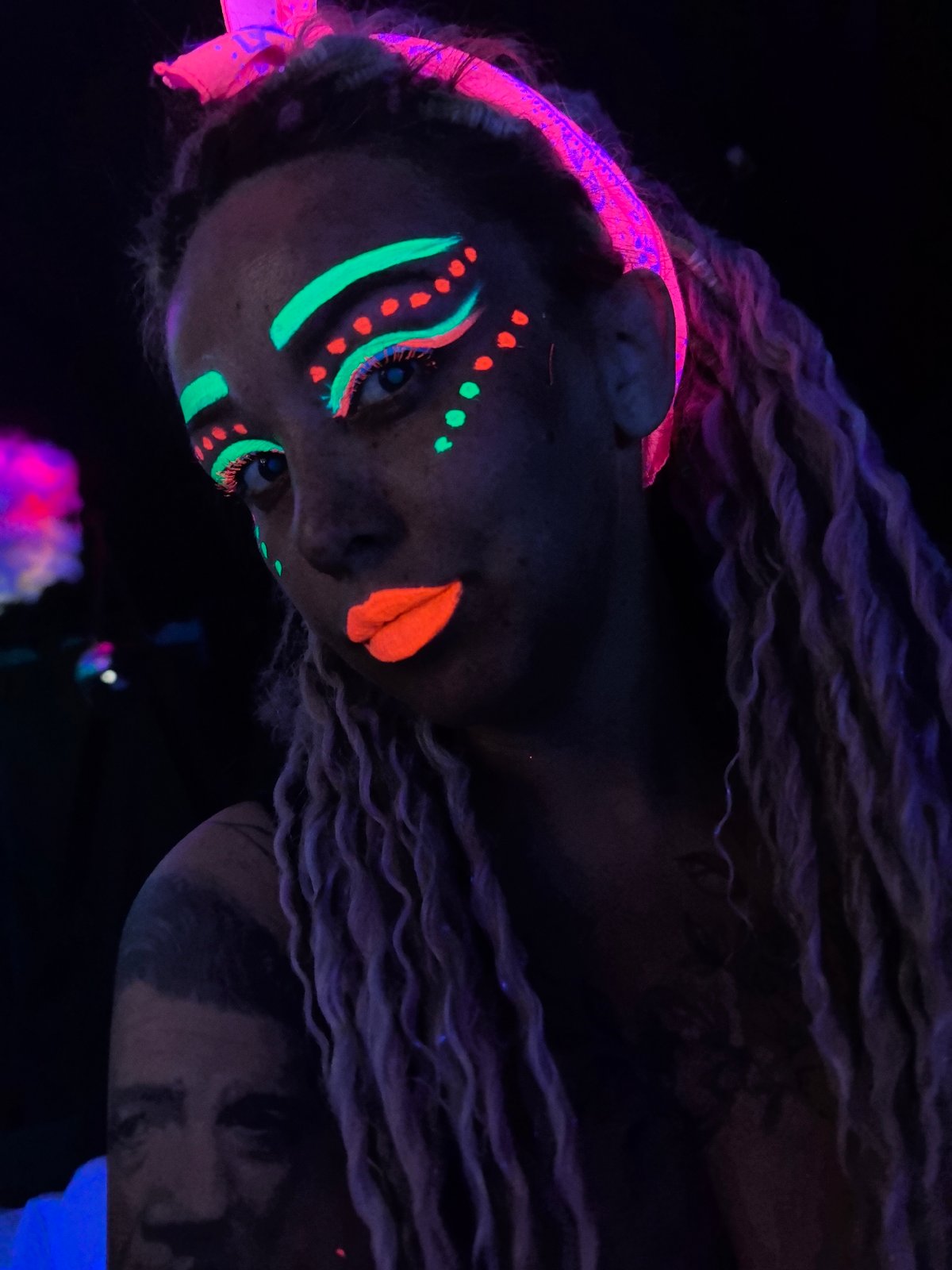 Person poses with neon makeup under blacklights in Russia