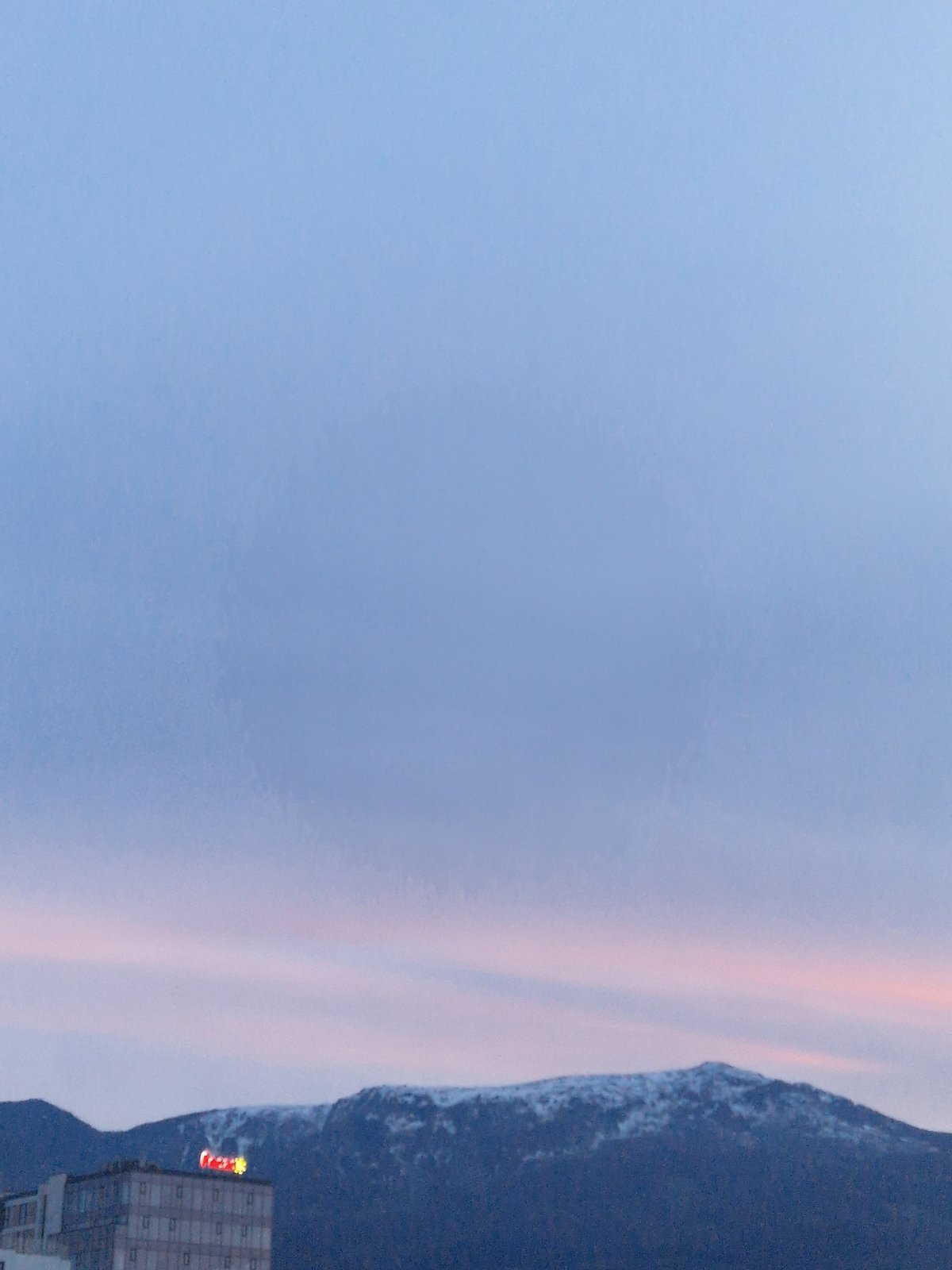 Twilight cityscape with pink horizon captured by witness