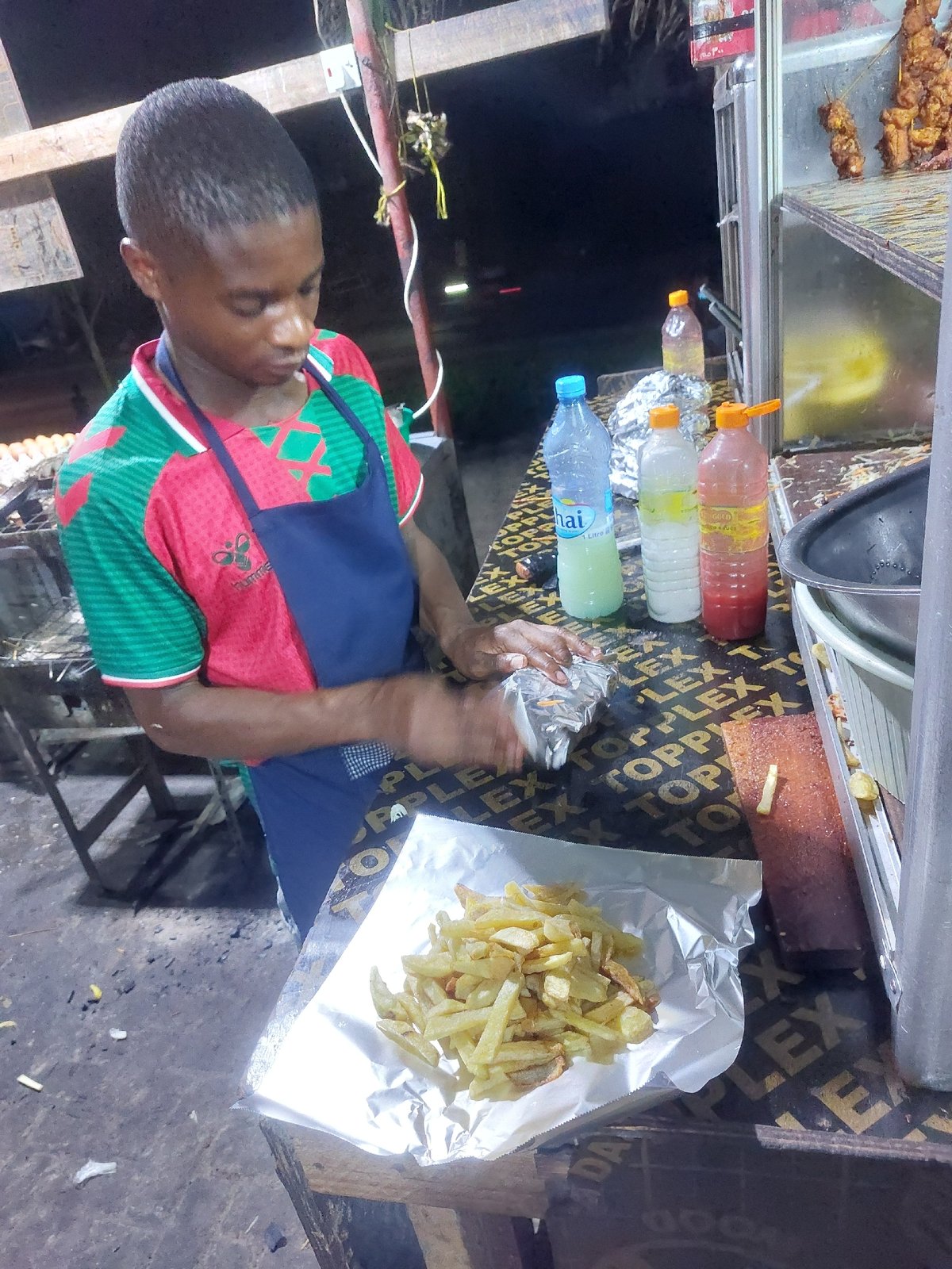 Street food vendor serves customers in Dar es-Salaam evening