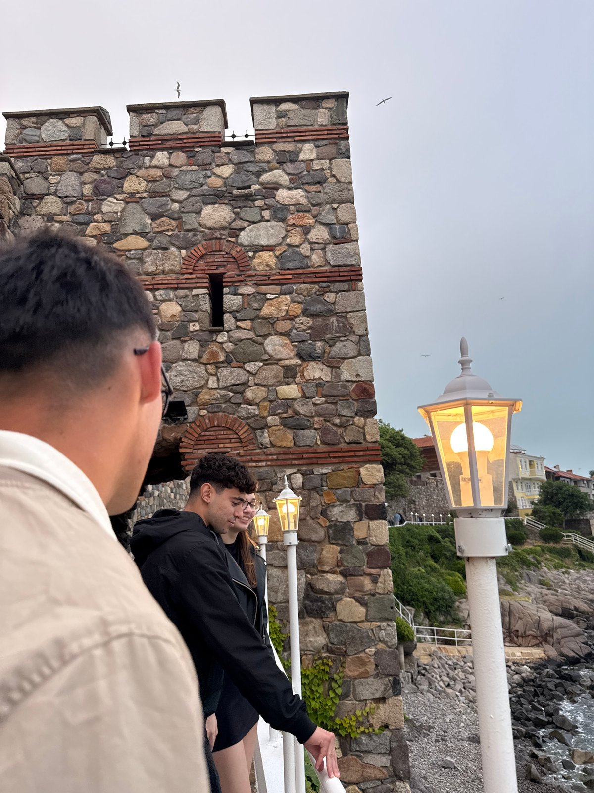 Tourists explore historic Sozopol coastline under overcast skies