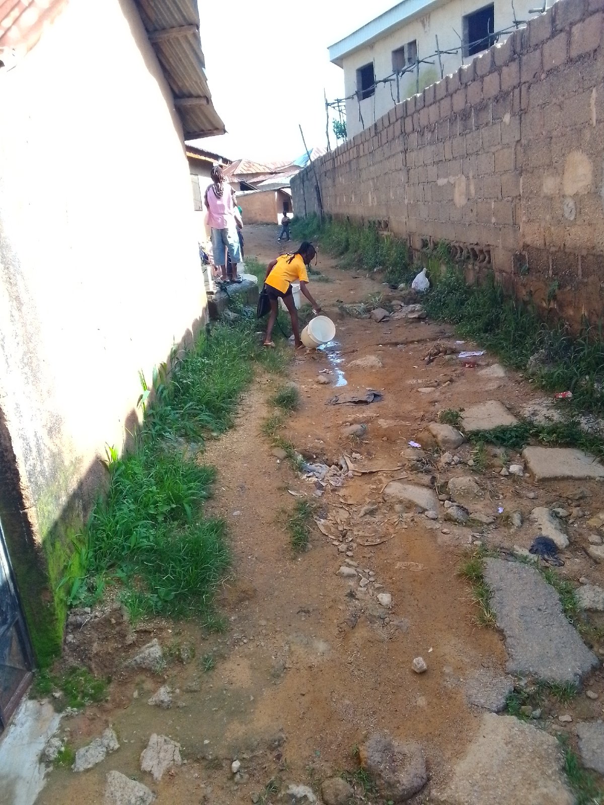 Daily water-carrying and foot traffic through a village settlement