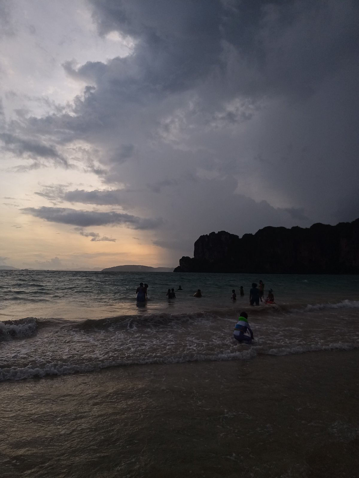 Tourists enjoy dramatic sunset at Ban Ao Nang beach