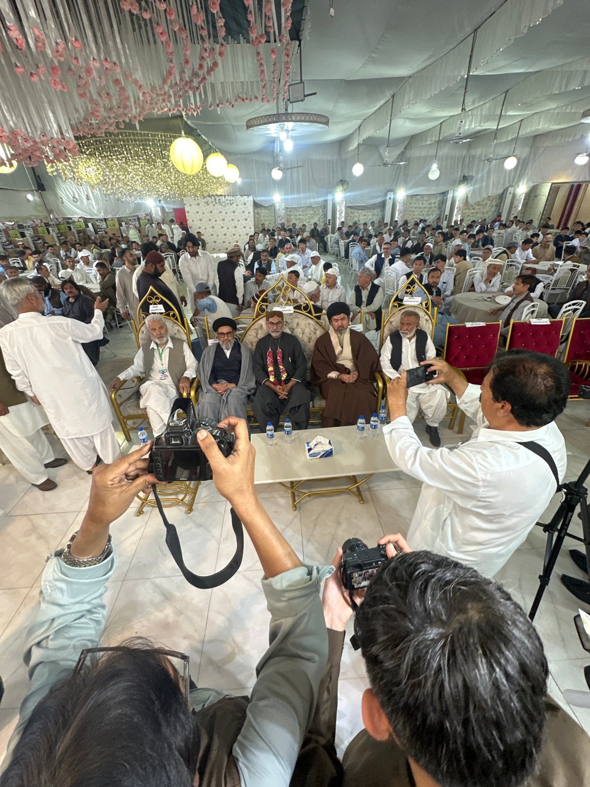 Men seated on golden chairs photographed at Quetta gathering
