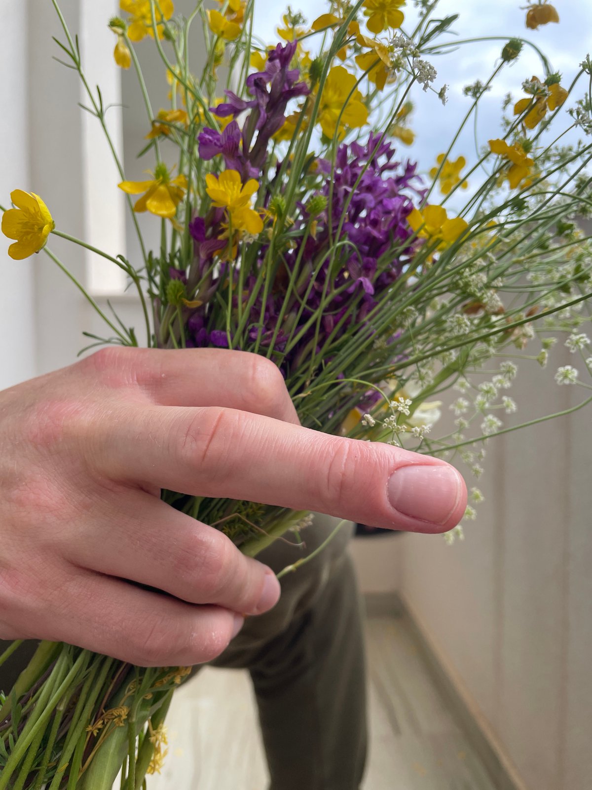 Person poses with wildflower bouquet in Montenegro coastal area