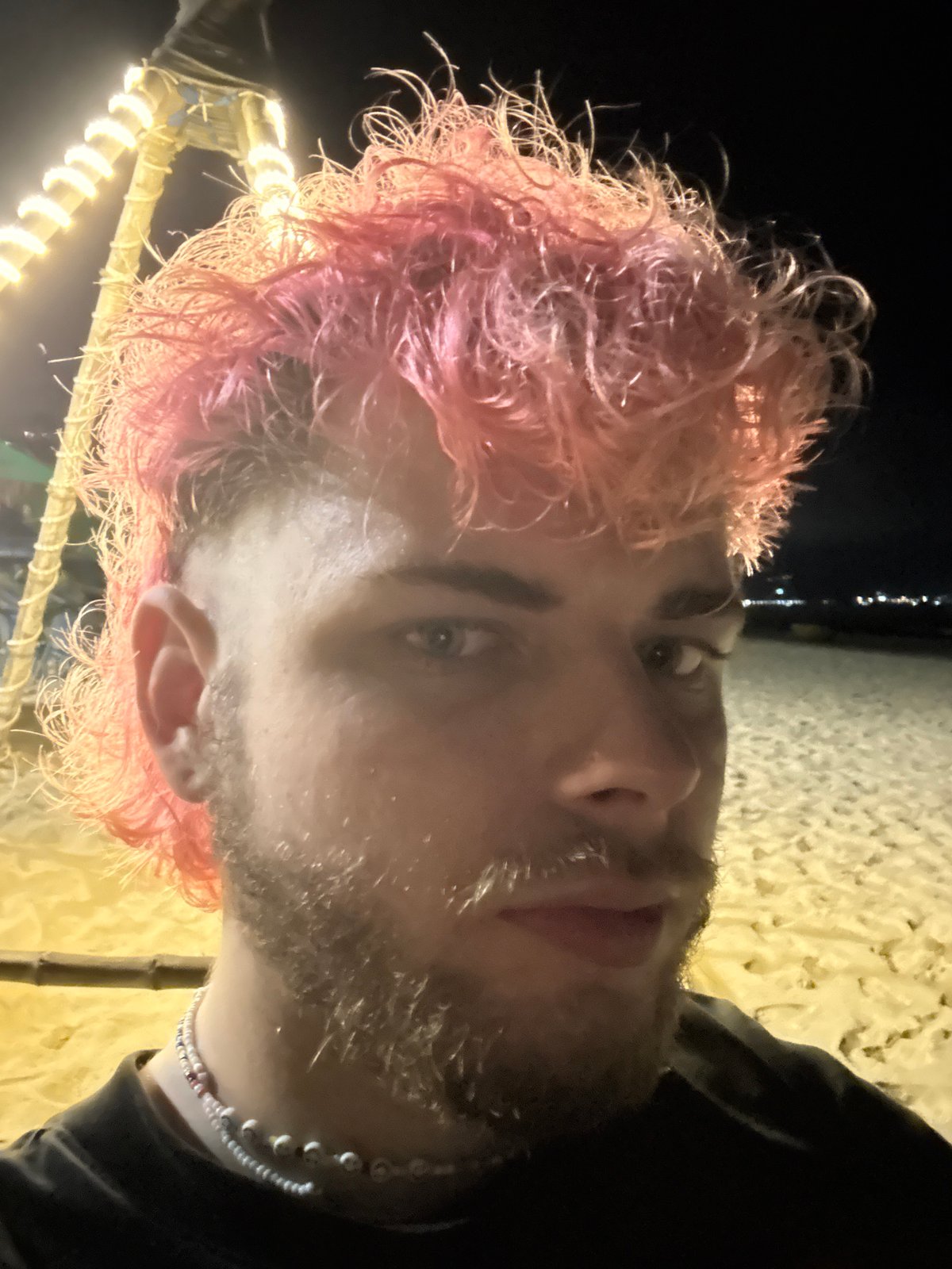 Pink-haired visitor enjoys illuminated beachside setup in Đà Nẵng