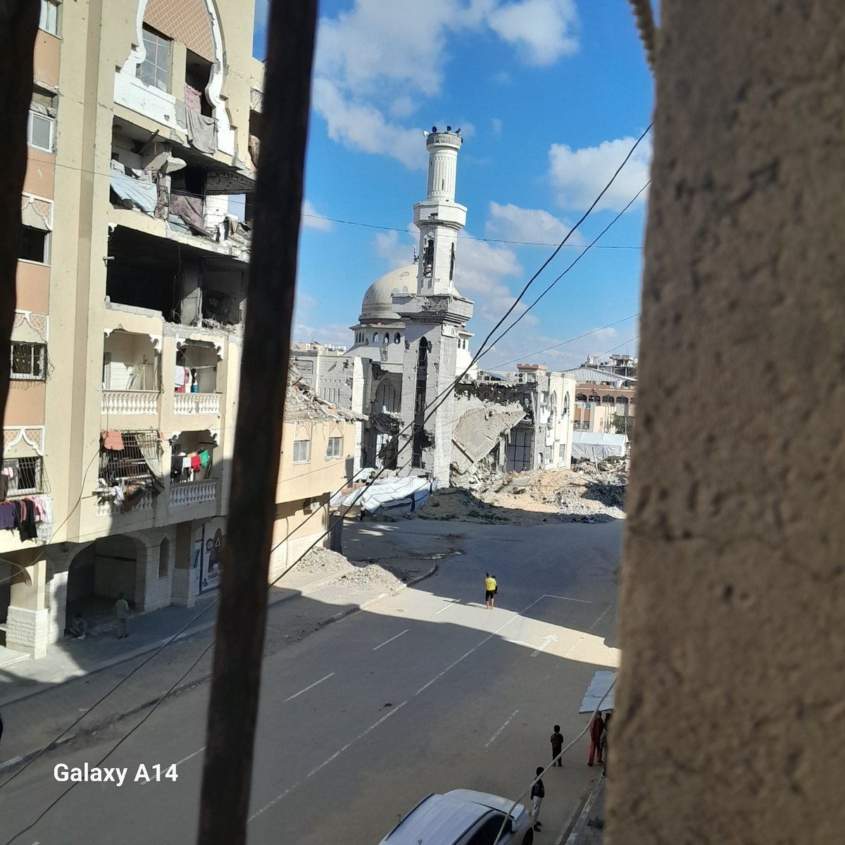 Damaged mosque with standing minaret documented in urban area