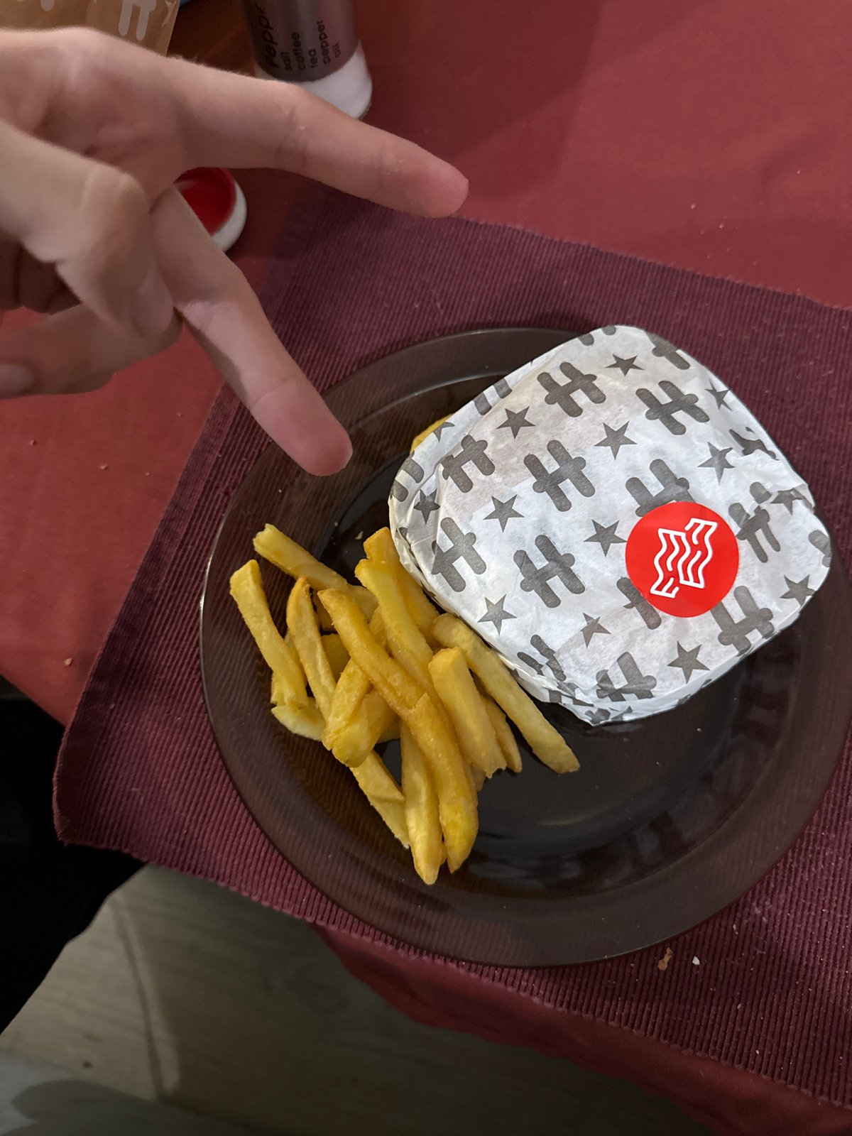 Person enjoys fast food meal while using smartphone in Bulgaria