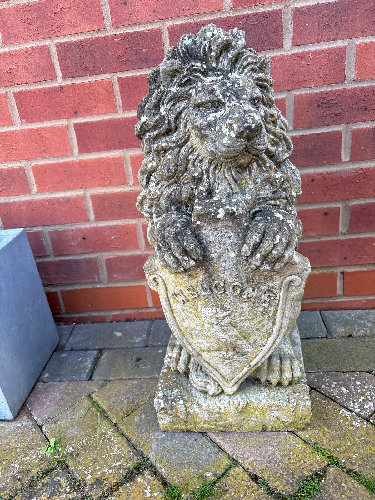 Stone lion statue with shield observed in Minsterley