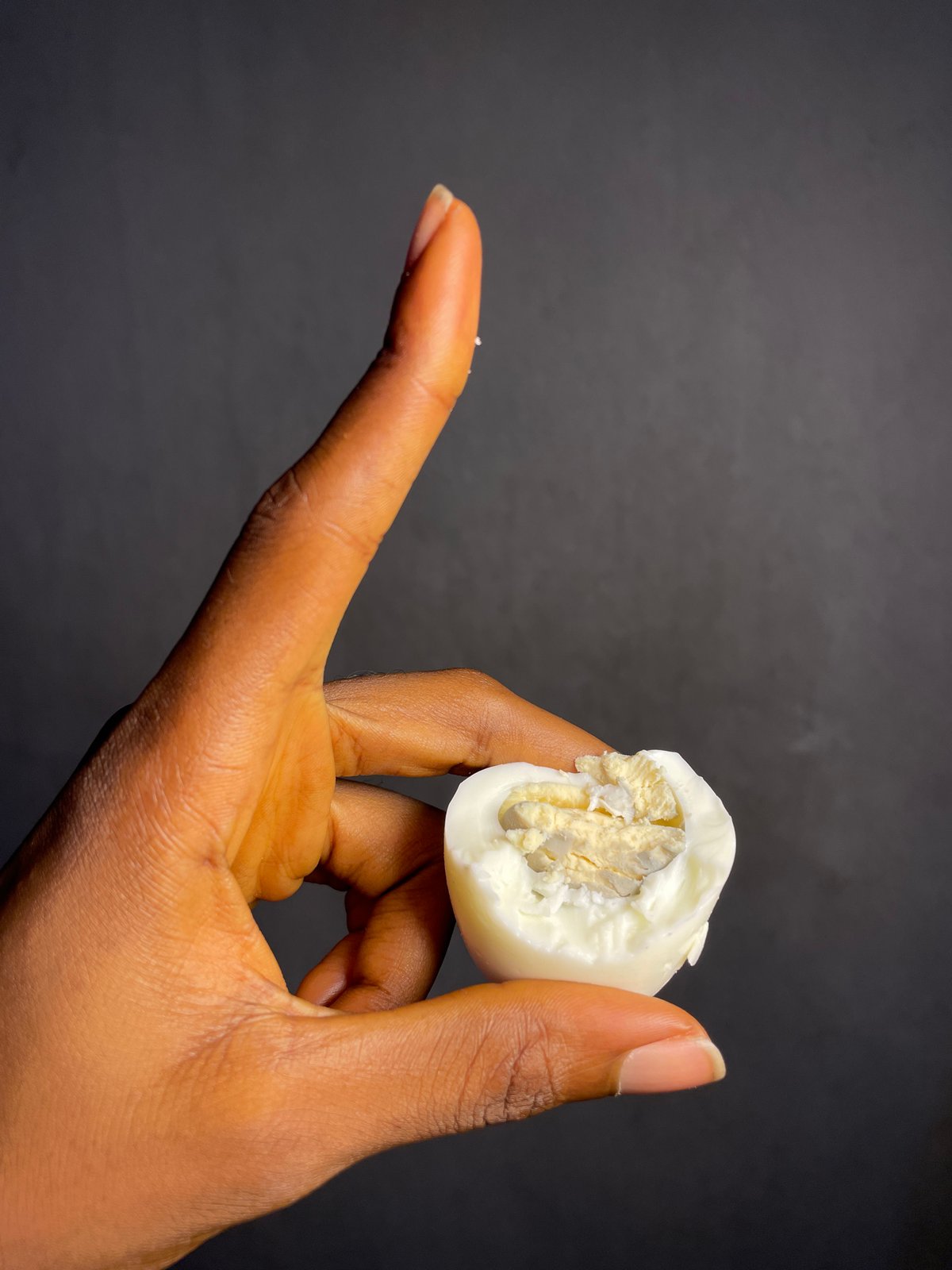 Person holds halved hard-boiled egg in Nkpor, Nigeria