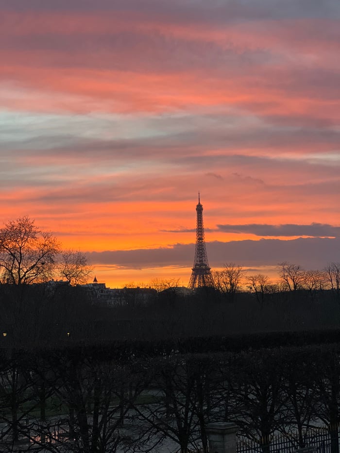 Dramatic sunset illuminates Paris skyline with Eiffel Tower silhouetted