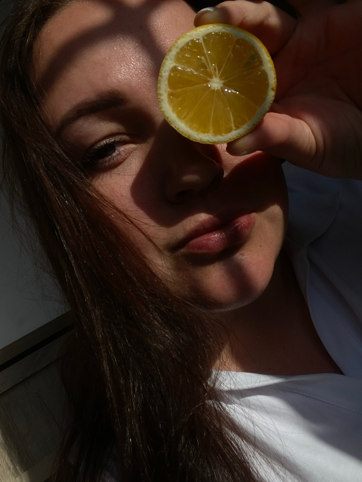 Woman holds lemon slice to eye in Sochi photo session