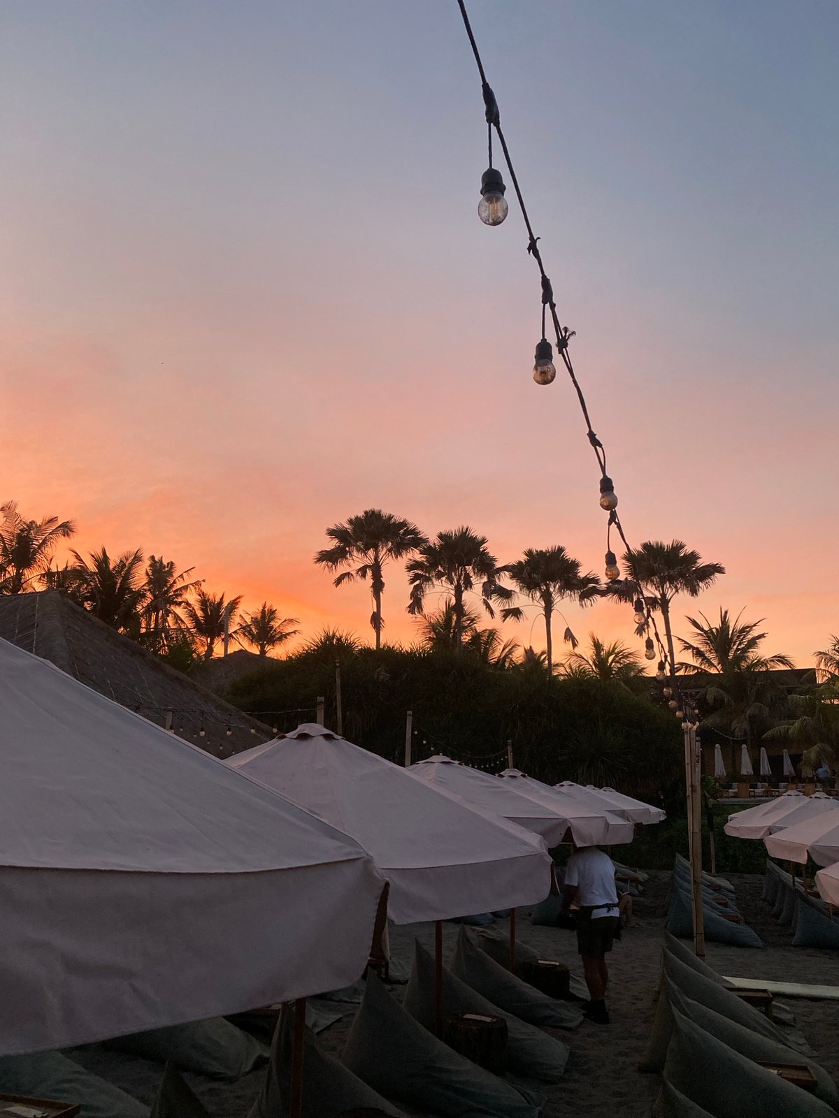 Sunset colors fade over North Kuta's dark sand beach.