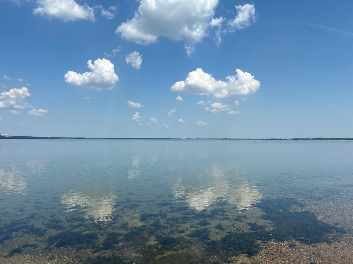 Tranquil waterfront scene captured under scattered clouds Sunday morning