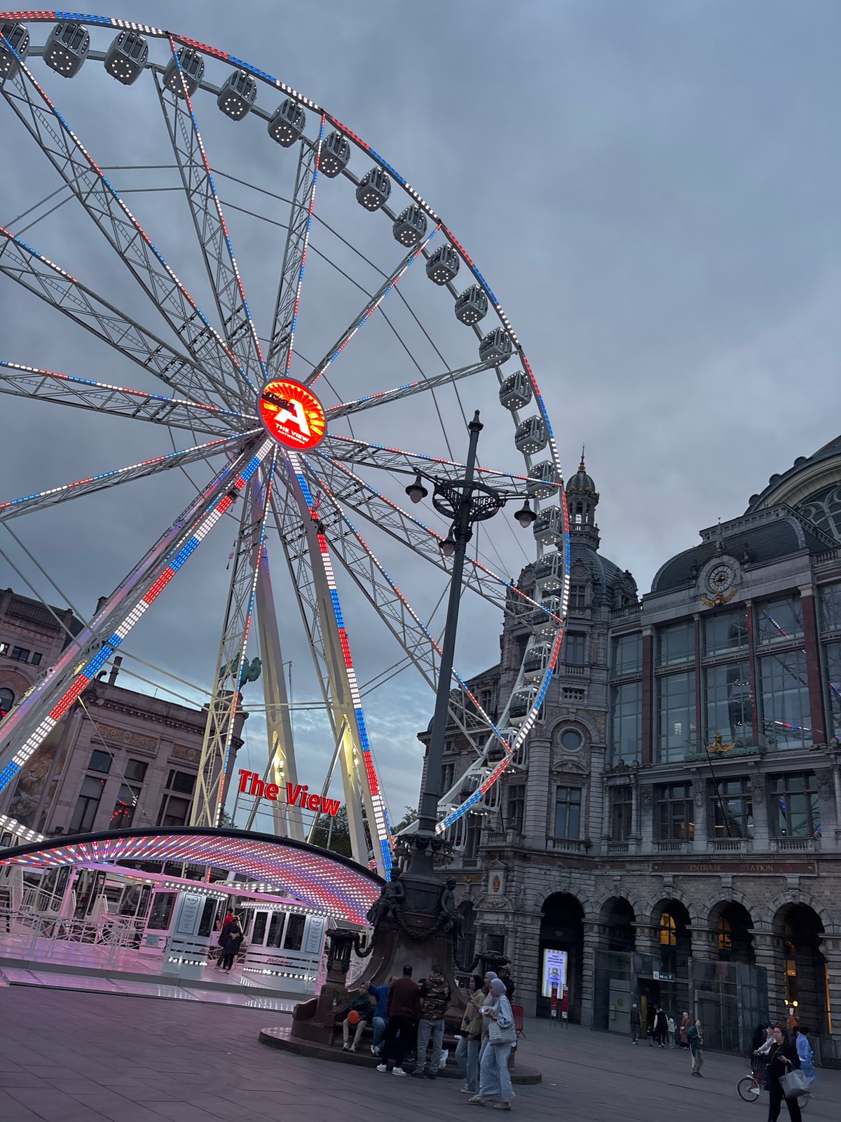 Illuminated Ferris wheel draws attention in historic Antwerp evening