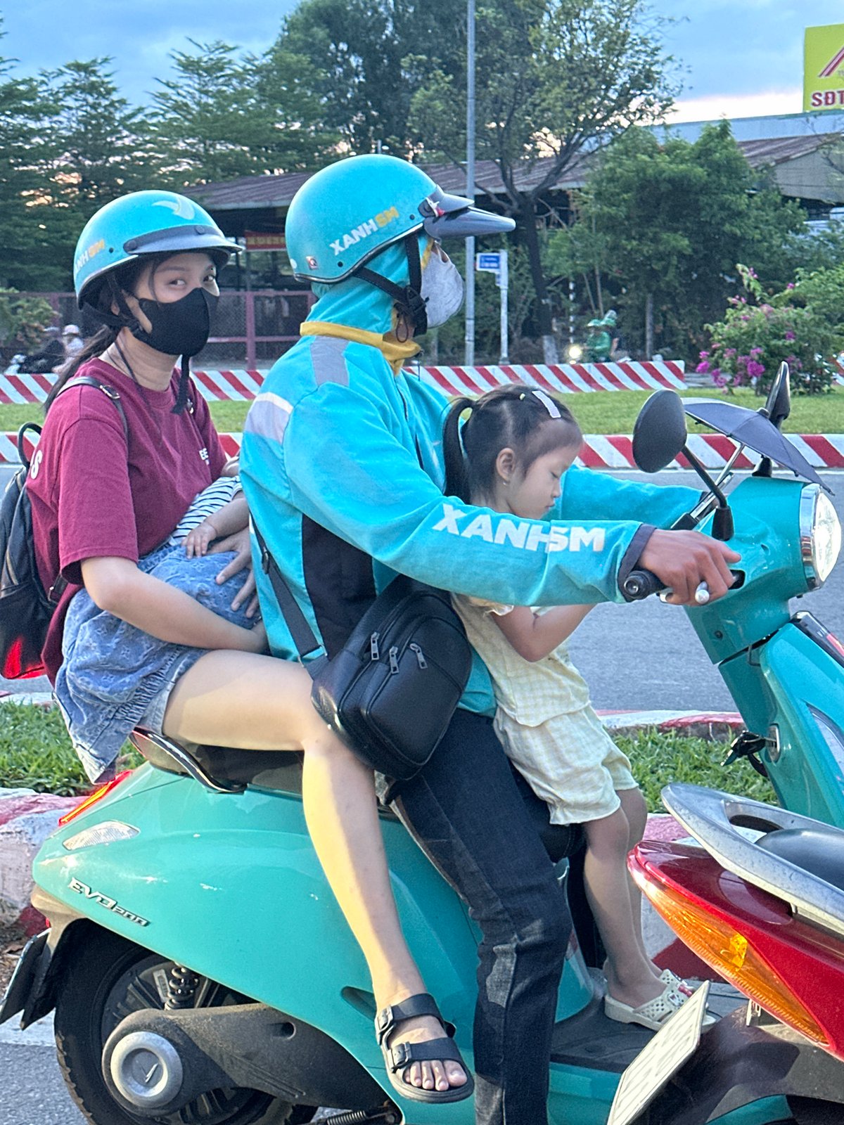 Midday motorbike traffic in Đà Nẵng, one bike hauling a tree