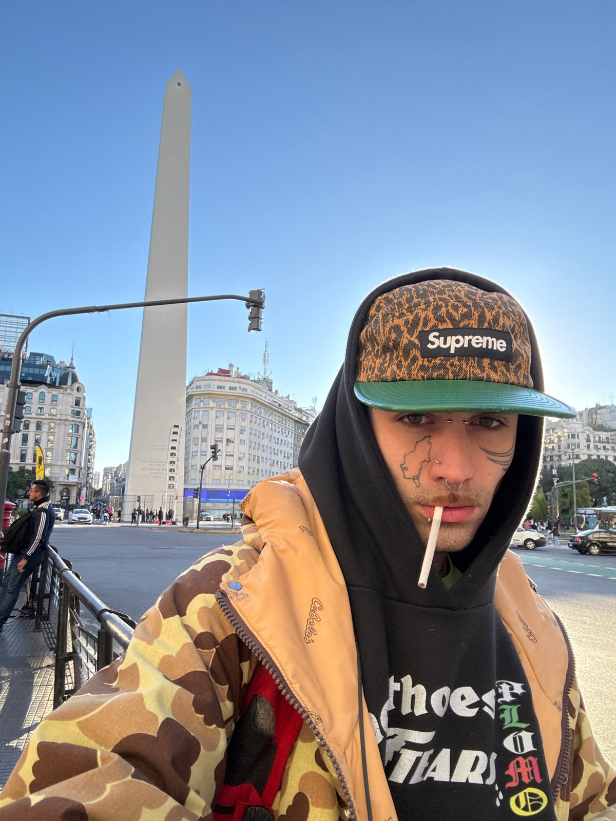 Tattooed individual photographed at Buenos Aires Obelisk, receives tattoo work