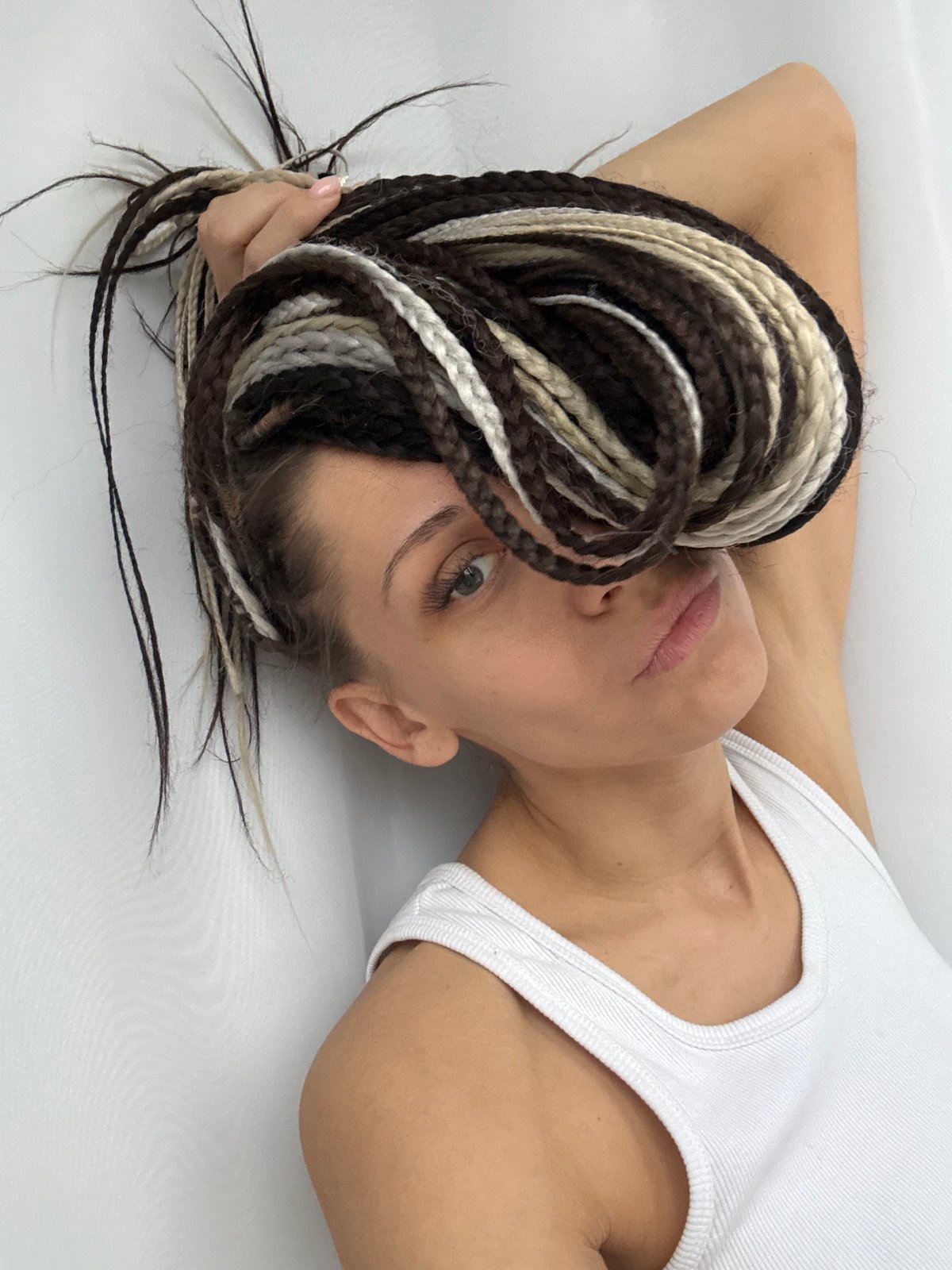 Woman with braided hair observed on white surface in Rusanovo