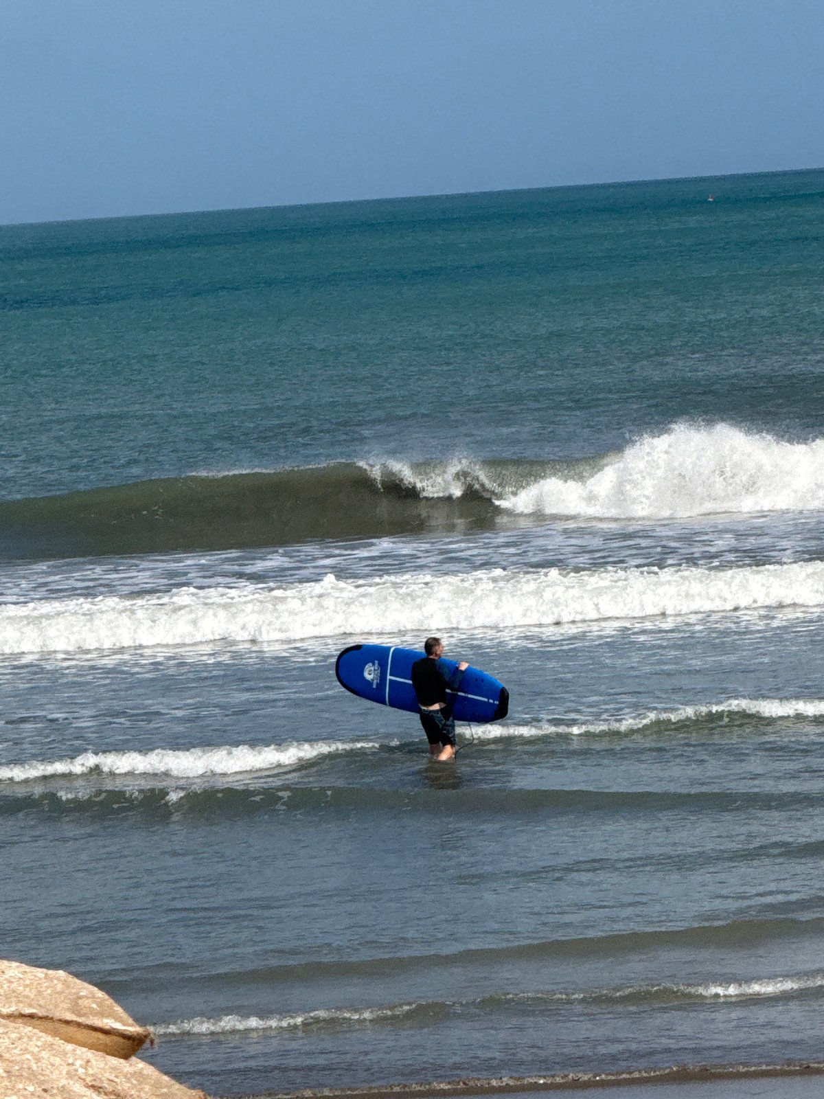 Surfers and beachgoers moving along Kuta Beach, Bali