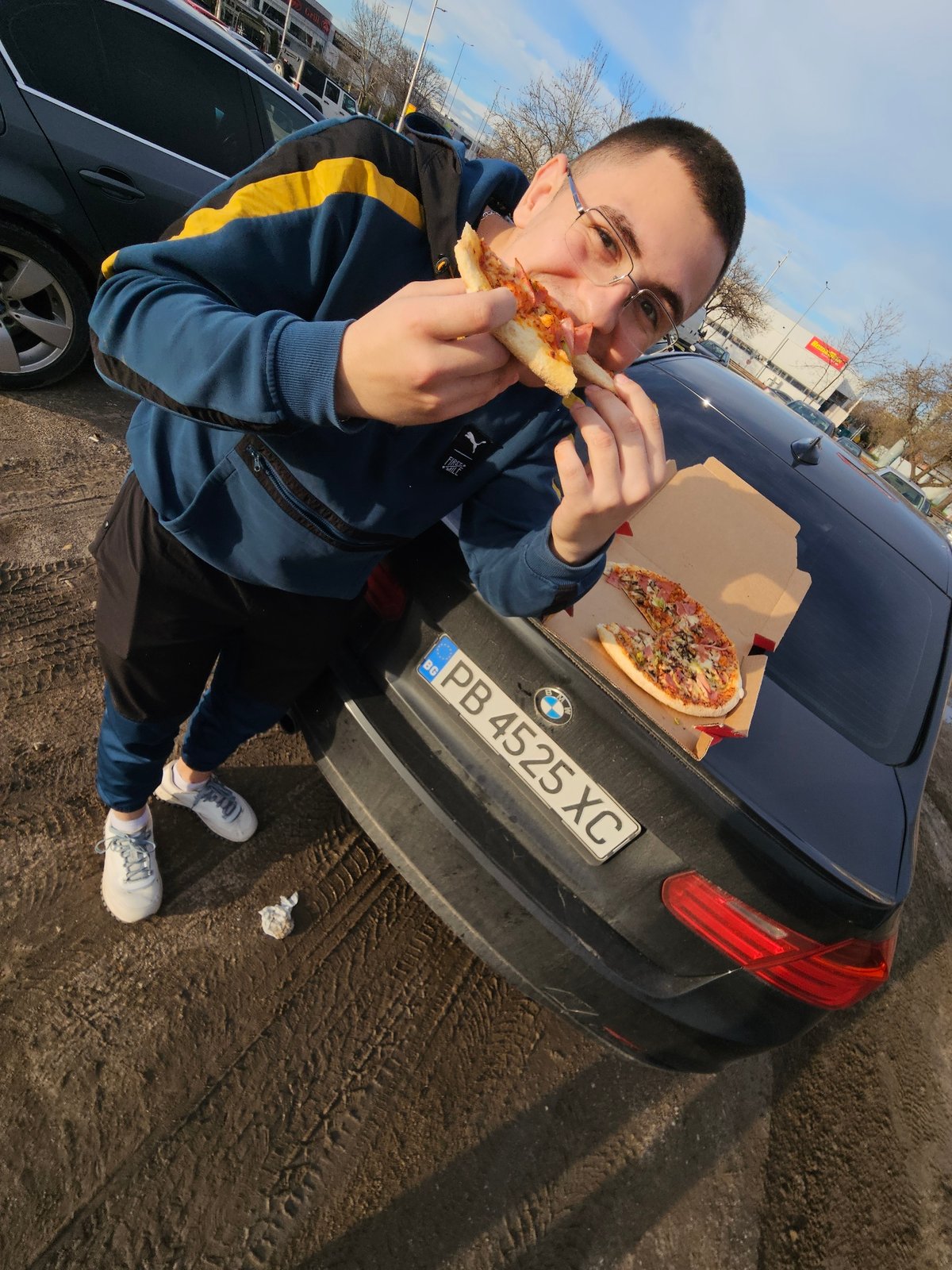 Man eats pizza in Plovdiv parking lot