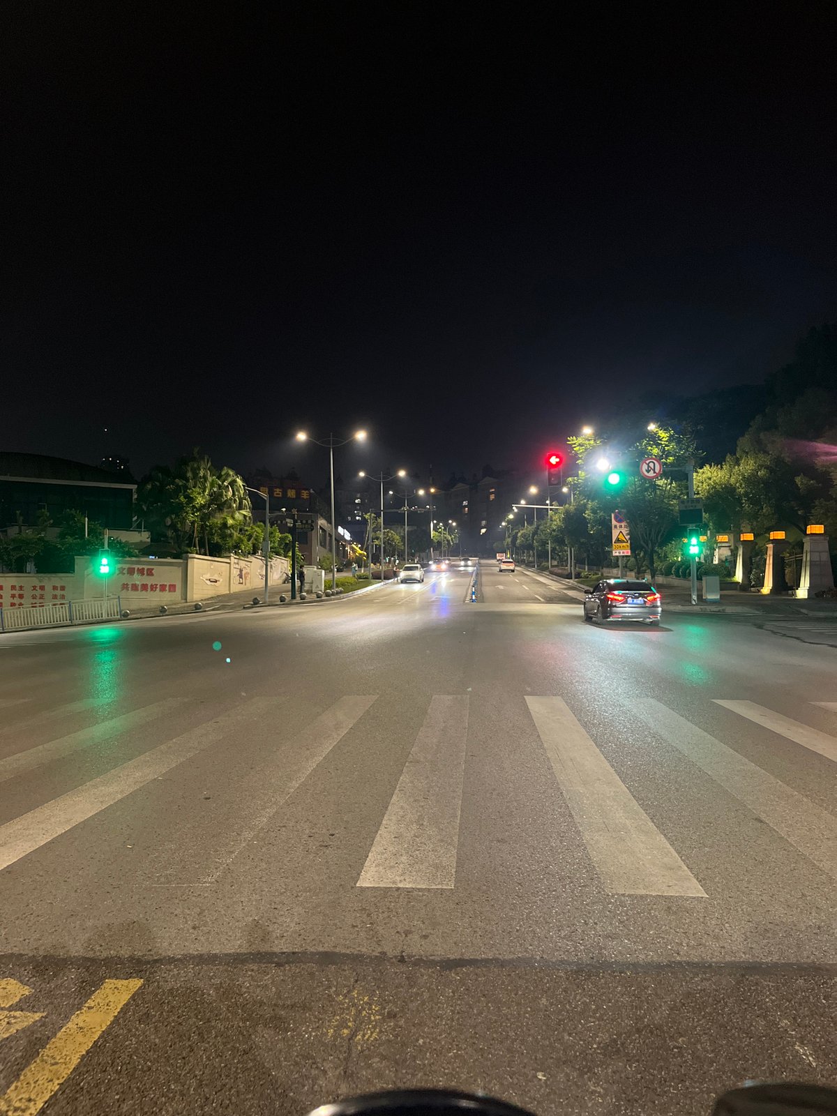 Wet nighttime street intersection documented in Jiulongpo District