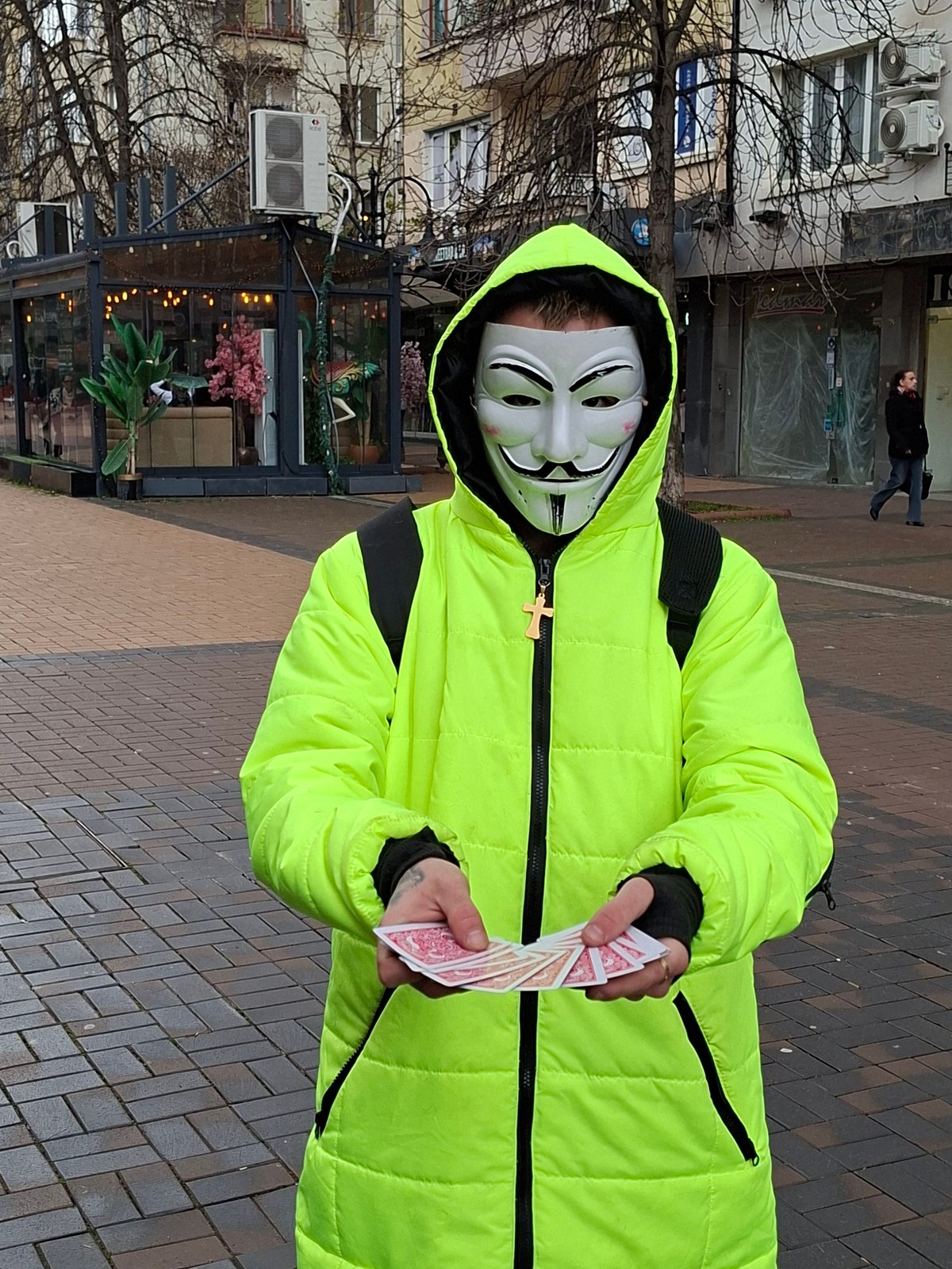 Masked figure with cards, husky dog spotted on Sofia sidewalk