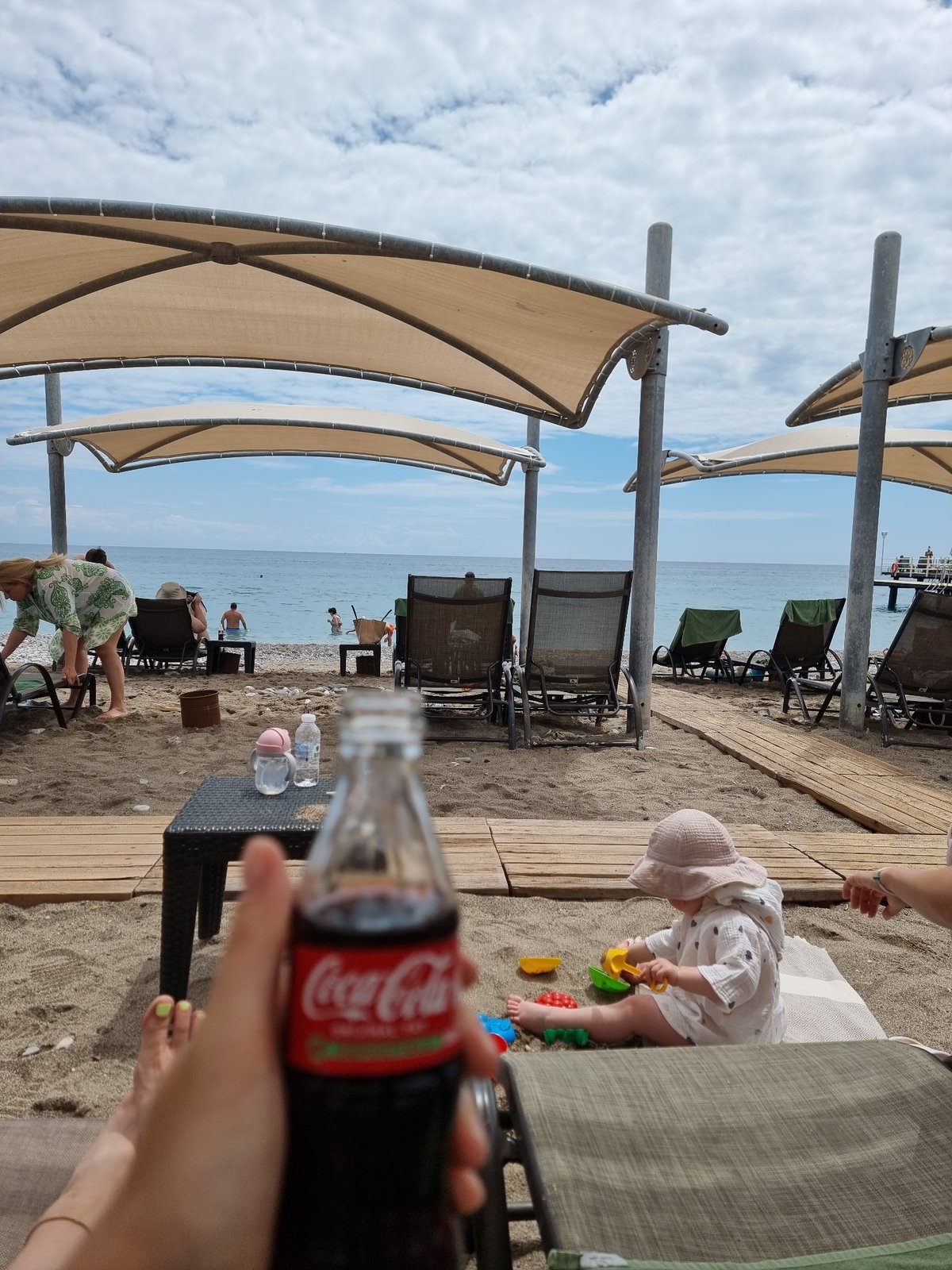 Baby in sunglasses enjoys morning at Turkish beach resort