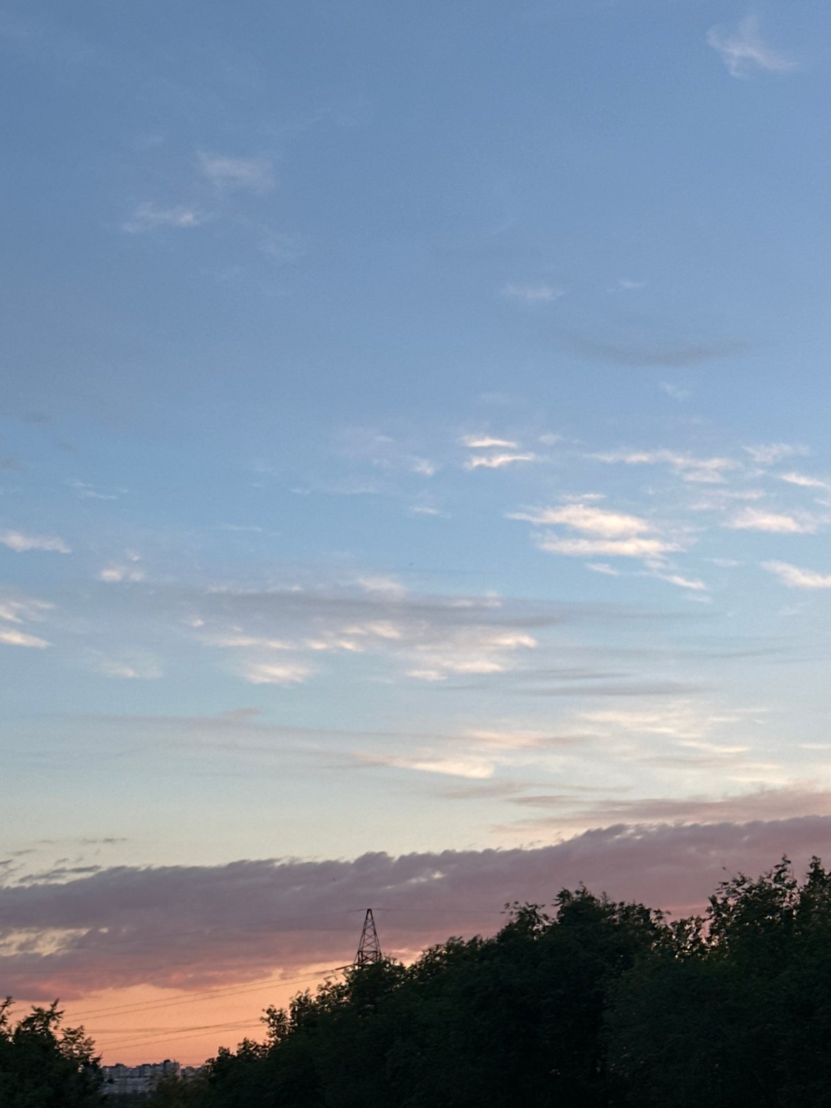 Sunset sky series tracking dusk light and clouds over an urban treeline