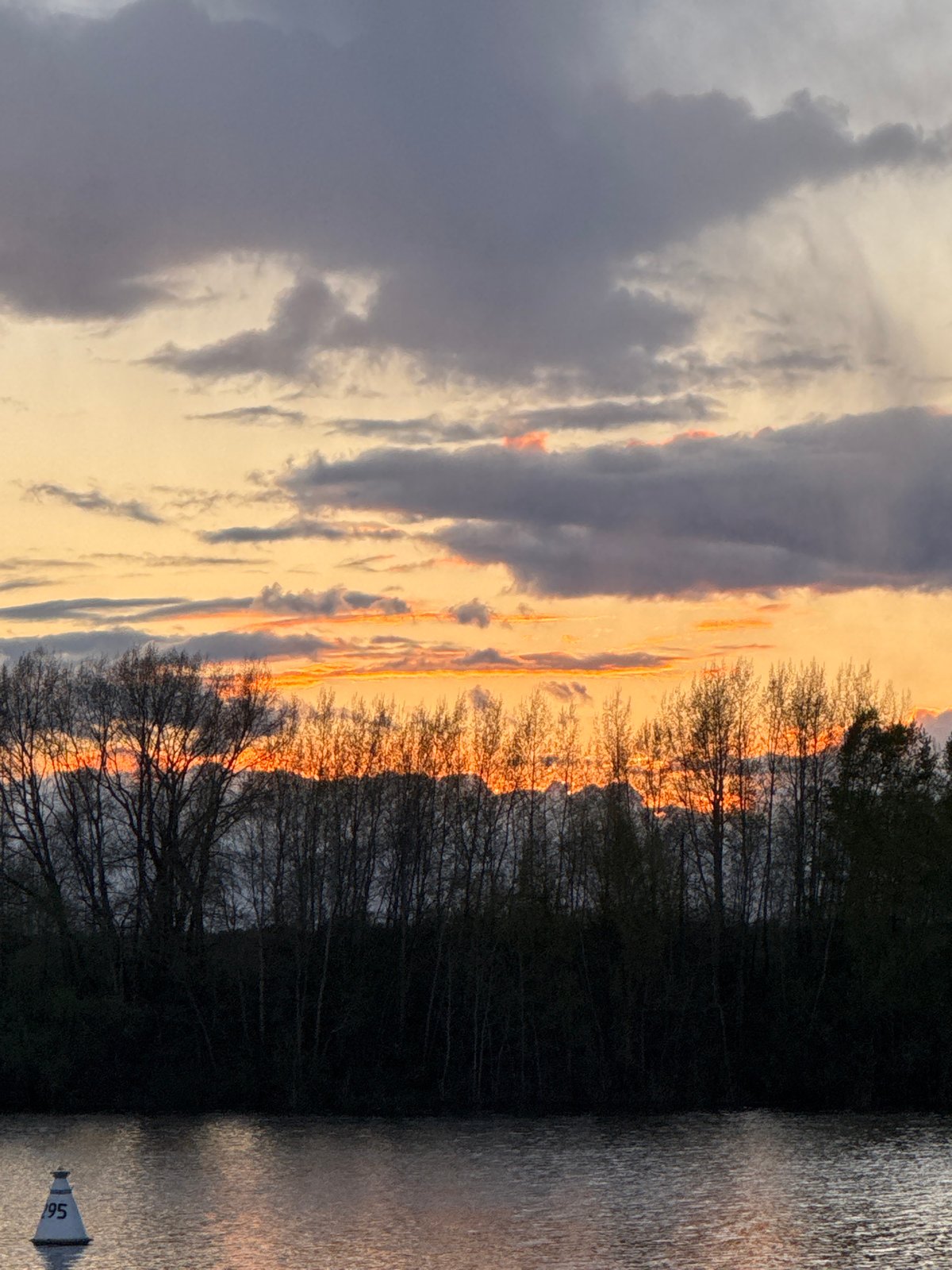 Sunset illuminates Kama River with golden clouds in Chaikovsky