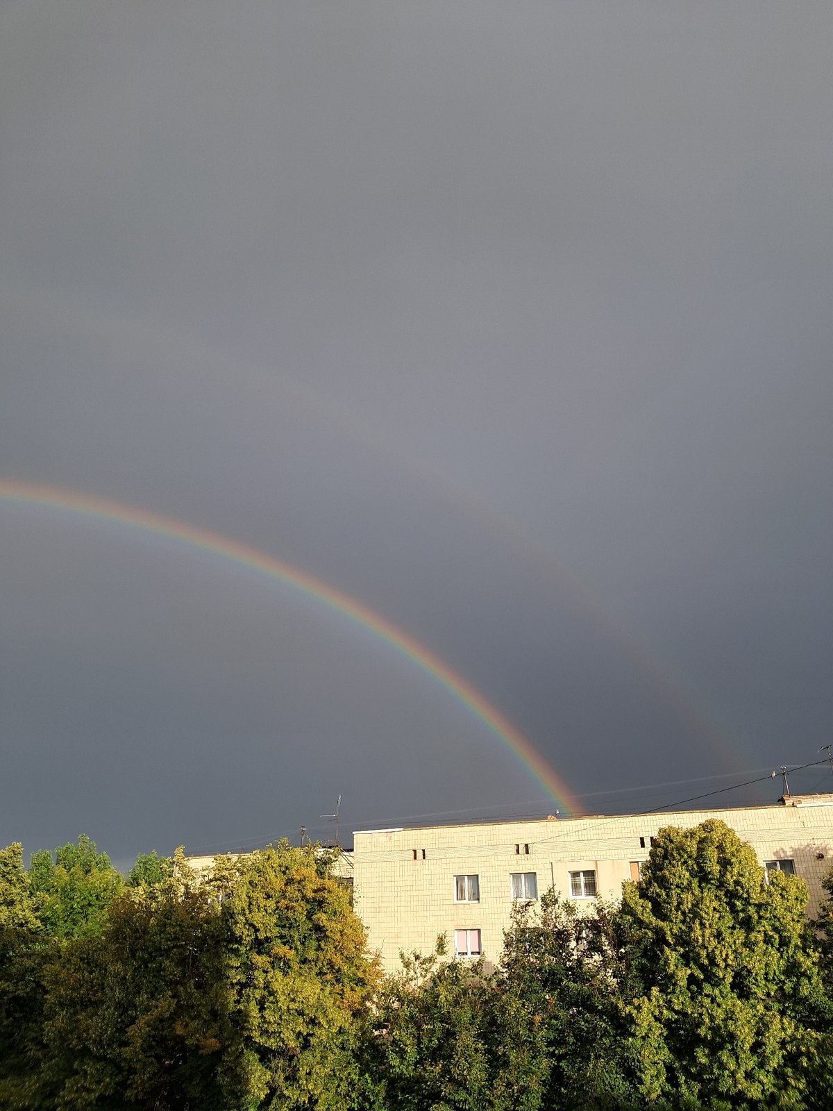 Double rainbow over an urban streetscape after rain