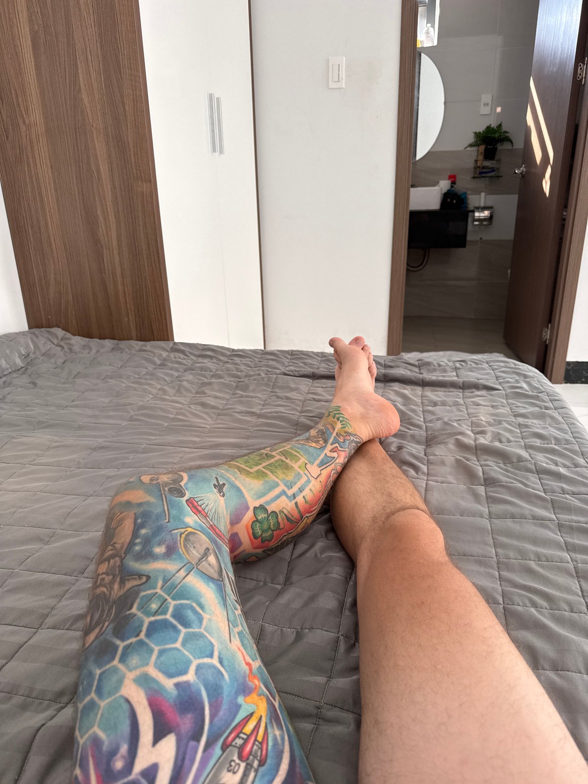 Tattooed leg photographed on bedspread in Vietnam