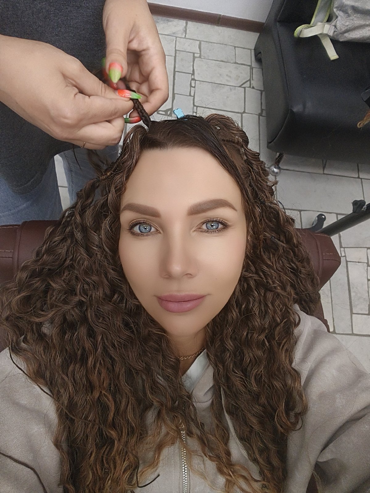 Woman receives hair styling session at salon