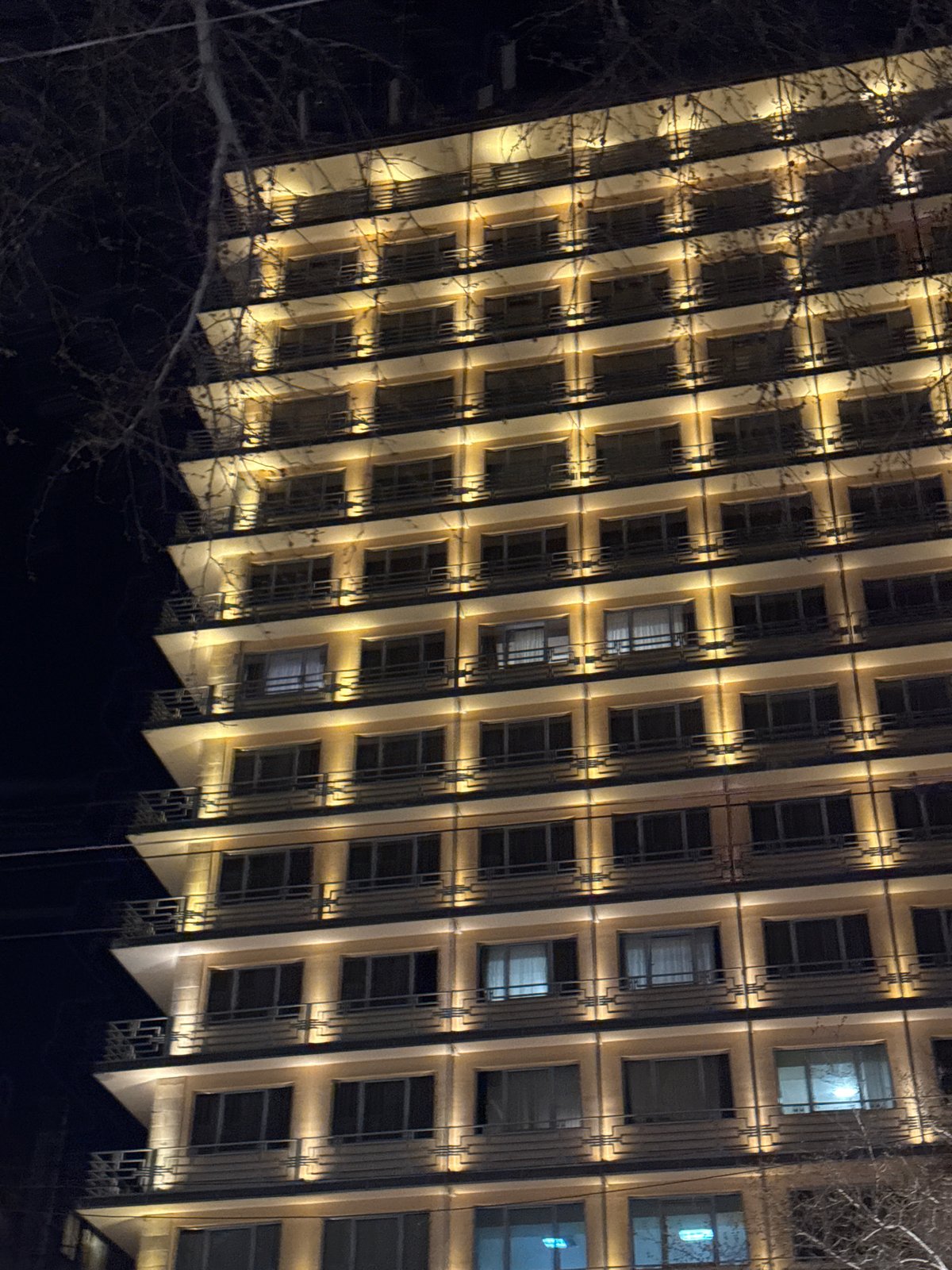 Illuminated Coca-Cola sign cycles colors on Yerevan building